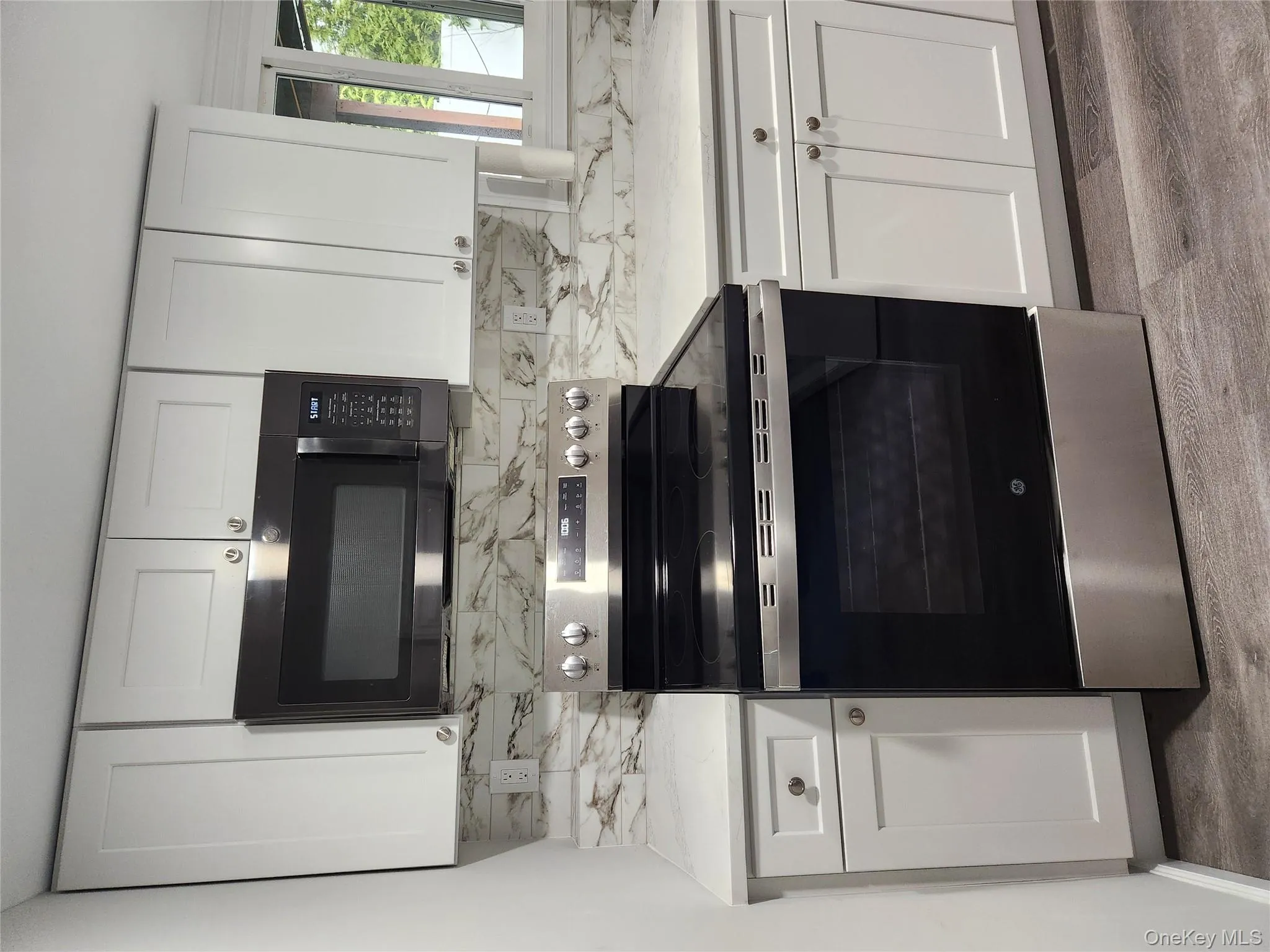 Kitchen with stainless steel range, white cabinets, and light wood-type flooring Kitchen with stainless steel range, white cabinets, and light wood-type flooring