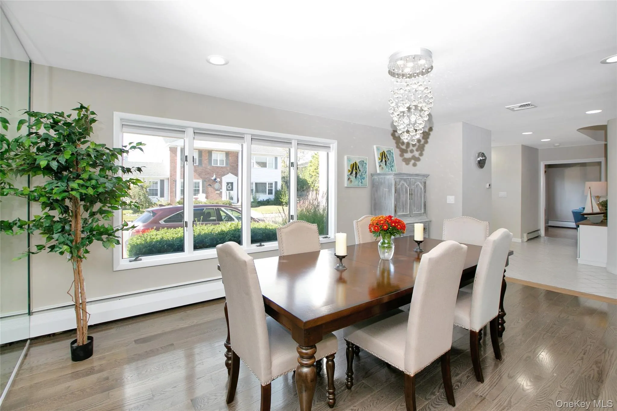 Dining room featuring light wood finished floors, recessed lighting, a baseboard radiator, and a chandelier Dining room featuring light wood finished floors, recessed lighting, a baseboard radiator, and a chandelier