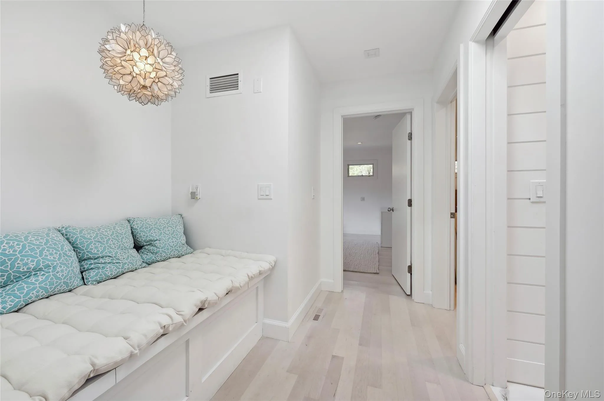 Hall featuring a chandelier and light hardwood / wood-style flooring Hall featuring a chandelier and light hardwood / wood-style flooring