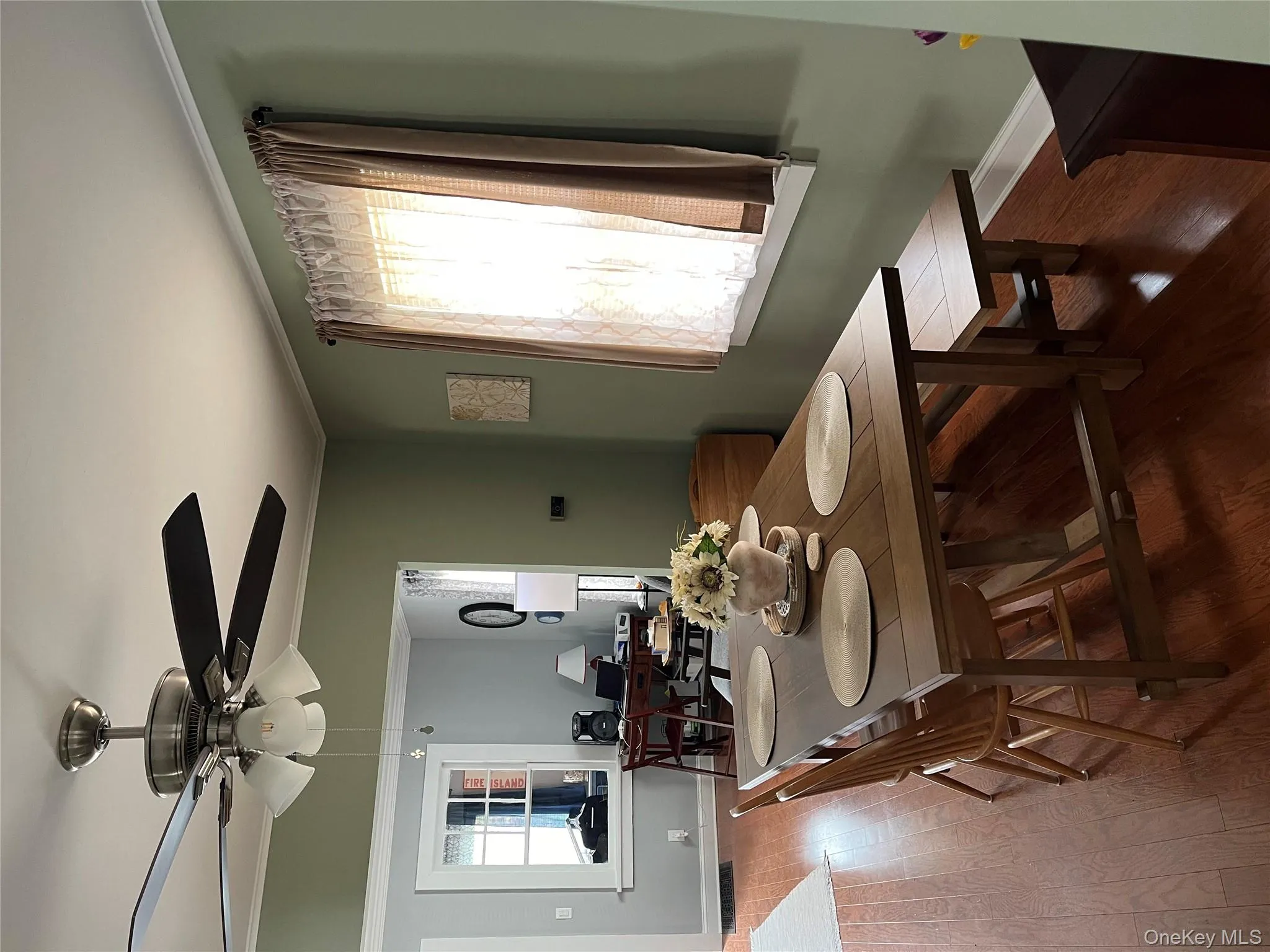 Dining space with dark wood-style flooring, ornamental molding, and a ceiling fan Dining space with dark wood-style flooring, ornamental molding, and a ceiling fan