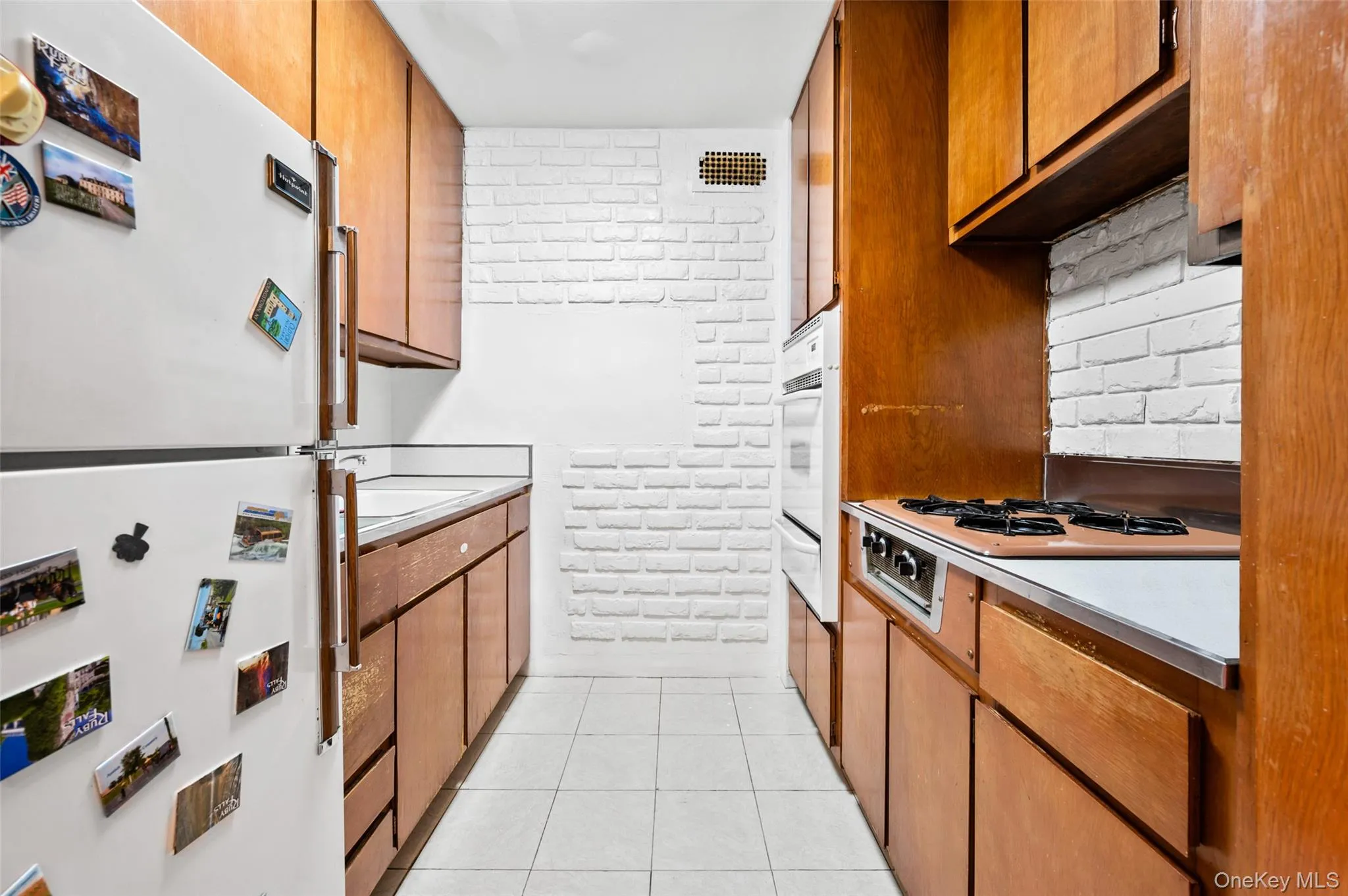Kitchen featuring sink, white appliances, backsplash, and light tile patterned floors Kitchen featuring sink, white appliances, backsplash, and light tile patterned floors