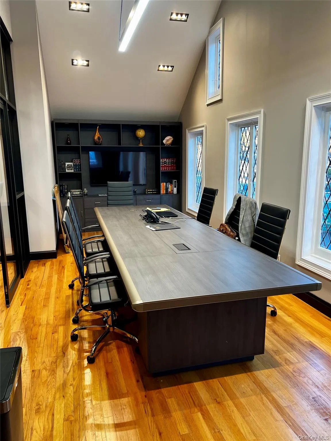 Home office with light hardwood / wood-style floors and high vaulted ceiling Home office with light hardwood / wood-style floors and high vaulted ceiling