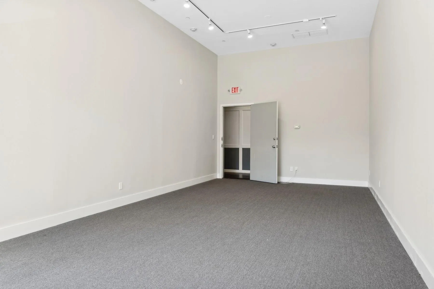 Unfurnished office featuring carpet and track lighting Unfurnished office featuring carpet and track lighting