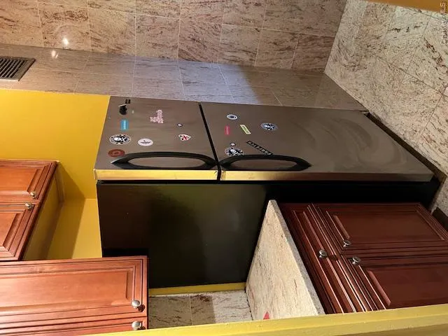 Kitchen with light stone counters and stainless steel refrigerator Kitchen with light stone counters and stainless steel refrigerator