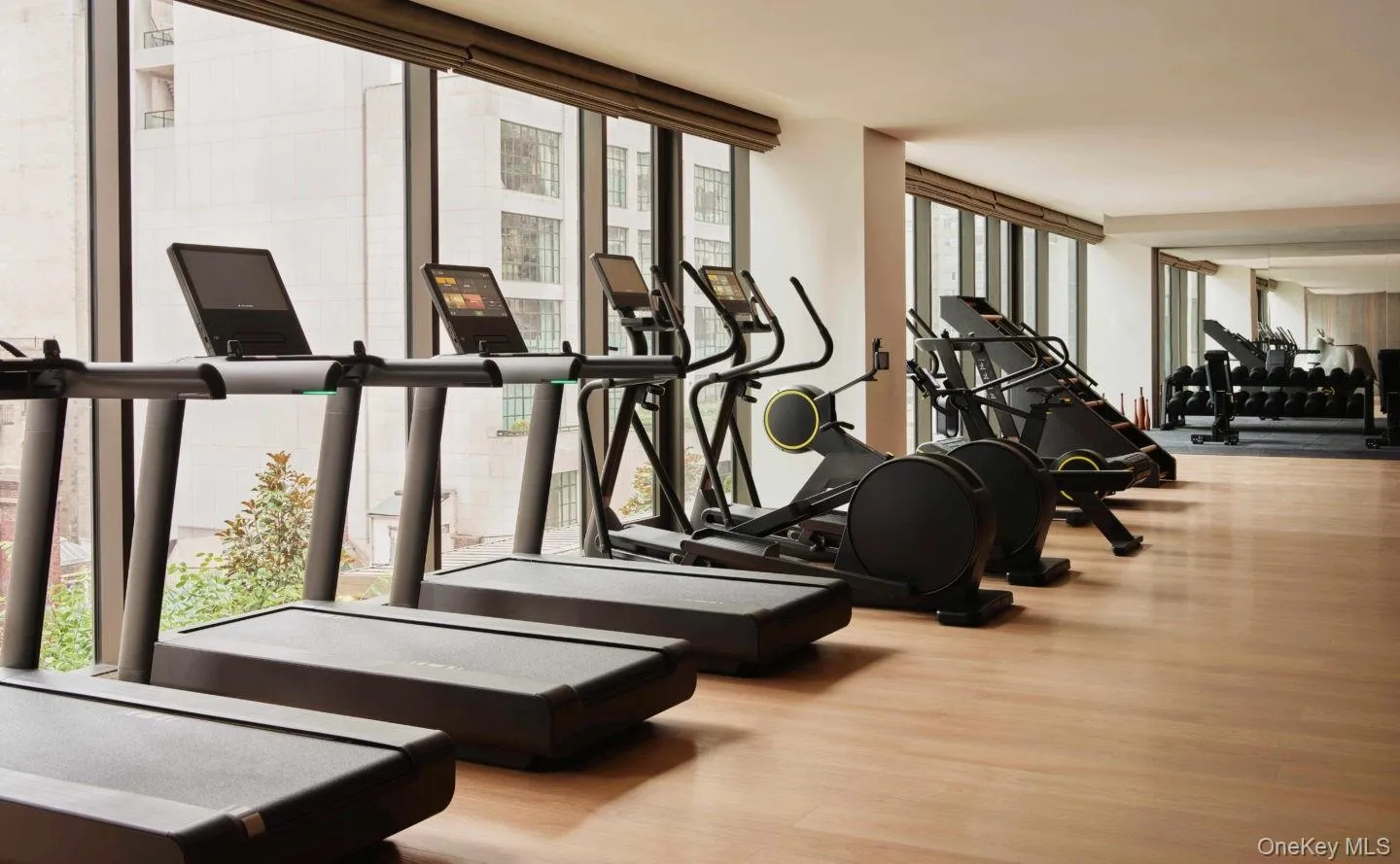 Exercise room with expansive windows and wood finished floors Exercise room with expansive windows and wood finished floors