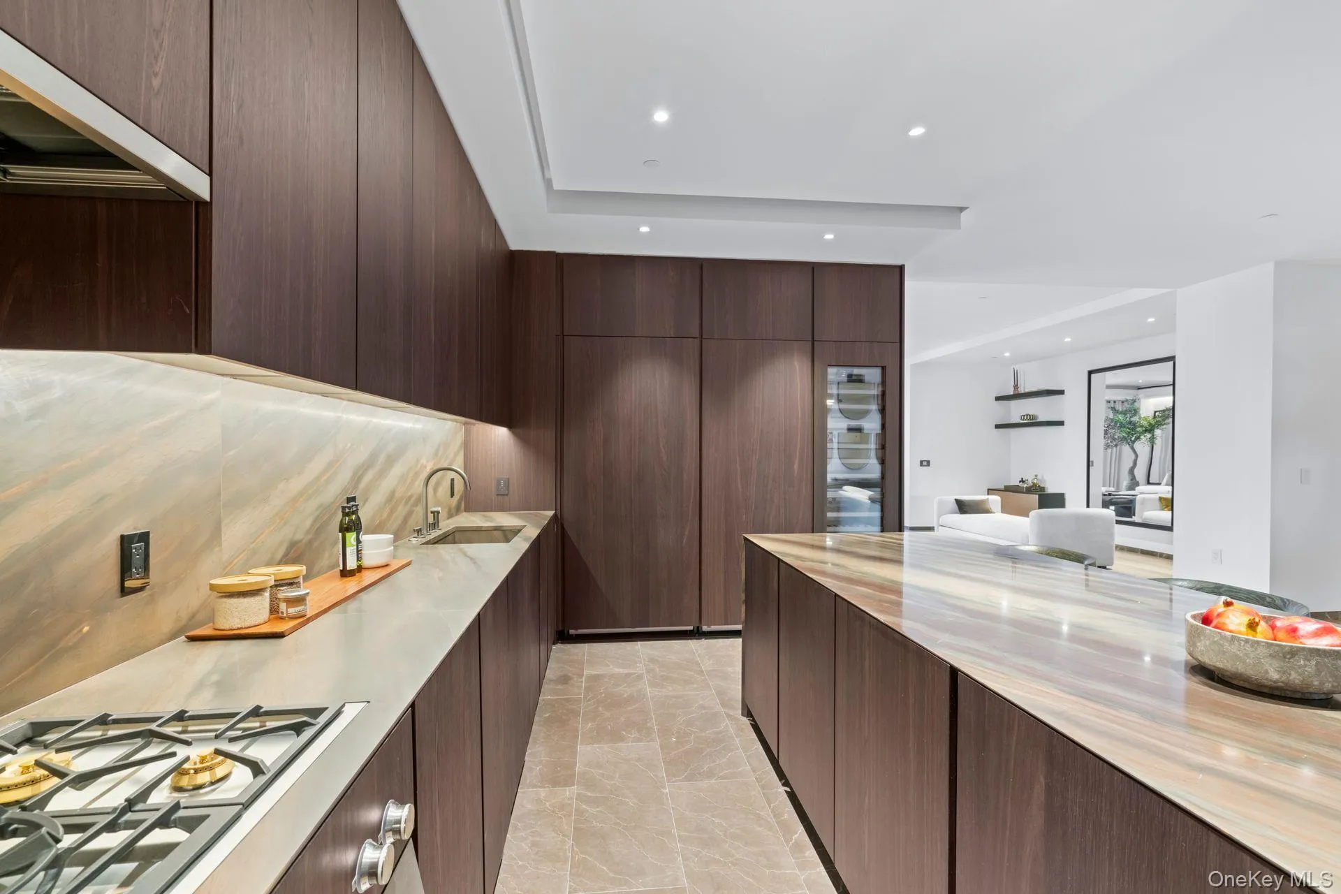 Kitchen featuring light countertops, stainless steel gas stovetop, dark brown cabinetry, a sink, and modern cabinets Kitchen featuring light countertops, stainless steel gas stovetop, dark brown cabinetry, a sink, and modern cabinets