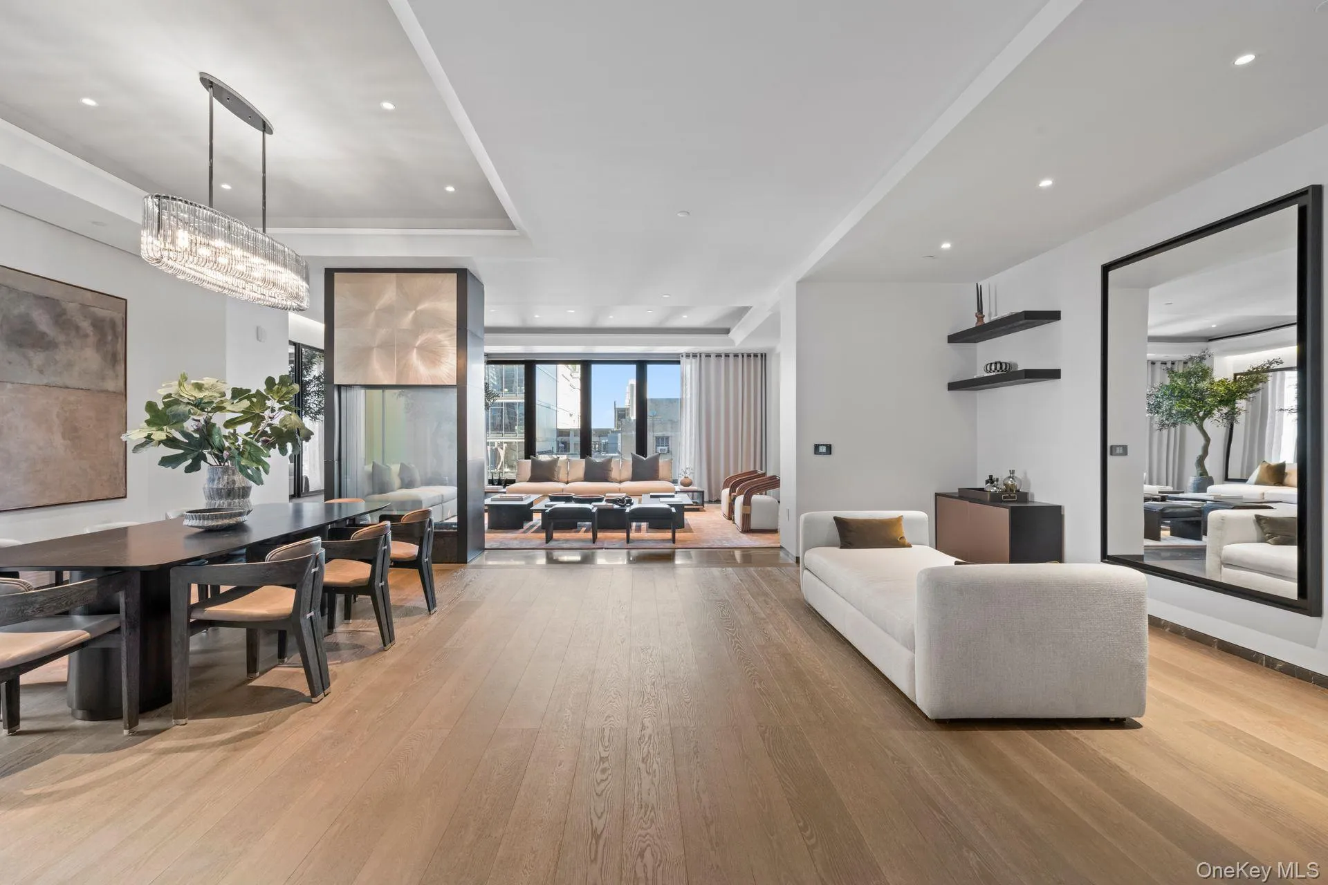 Living area featuring light wood-type flooring, a raised ceiling, and recessed lighting Living area featuring light wood-type flooring, a raised ceiling, and recessed lighting