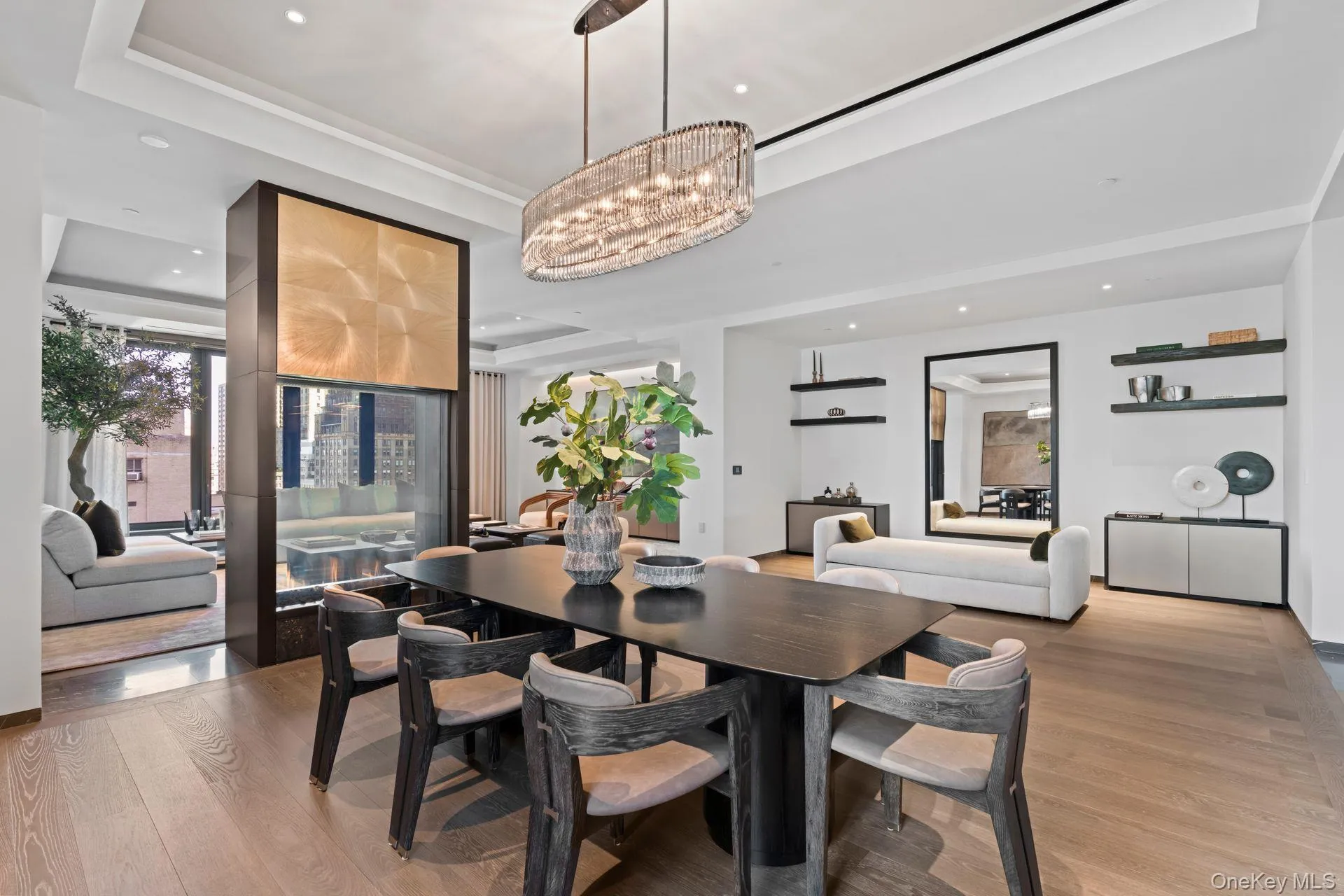 Dining area with a raised ceiling, light wood-style flooring, and a notable chandelier Dining area with a raised ceiling, light wood-style flooring, and a notable chandelier