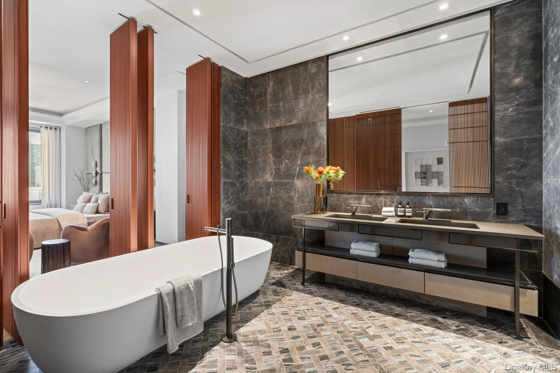 Full bathroom featuring a freestanding tub, a sink, tile walls, and double vanity Full bathroom featuring a freestanding tub, a sink, tile walls, and double vanity