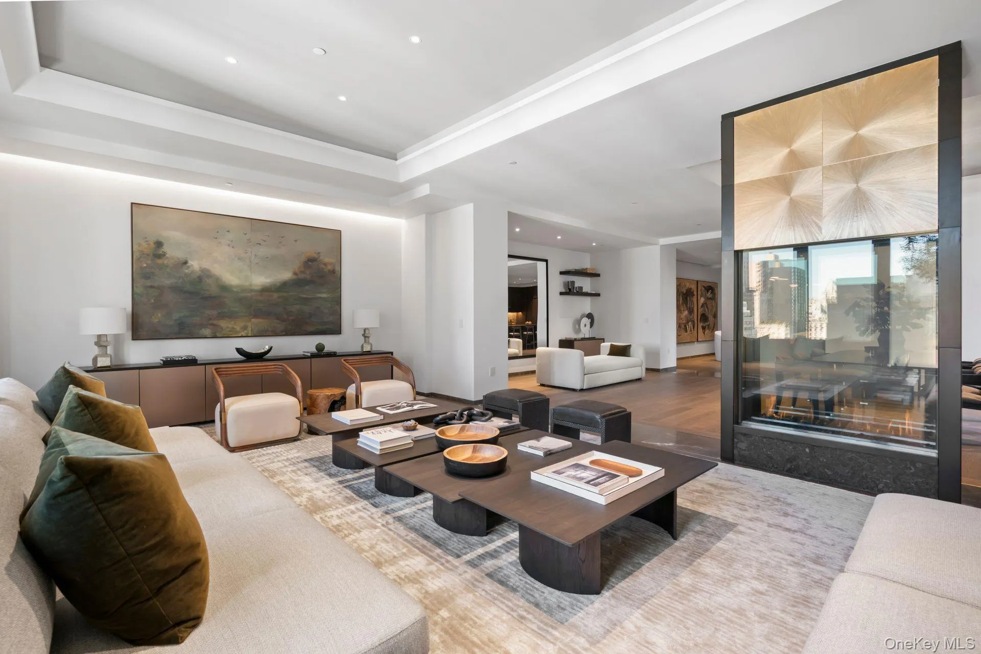 Living room with a tray ceiling, wood finished floors, and recessed lighting Living room with a tray ceiling, wood finished floors, and recessed lighting