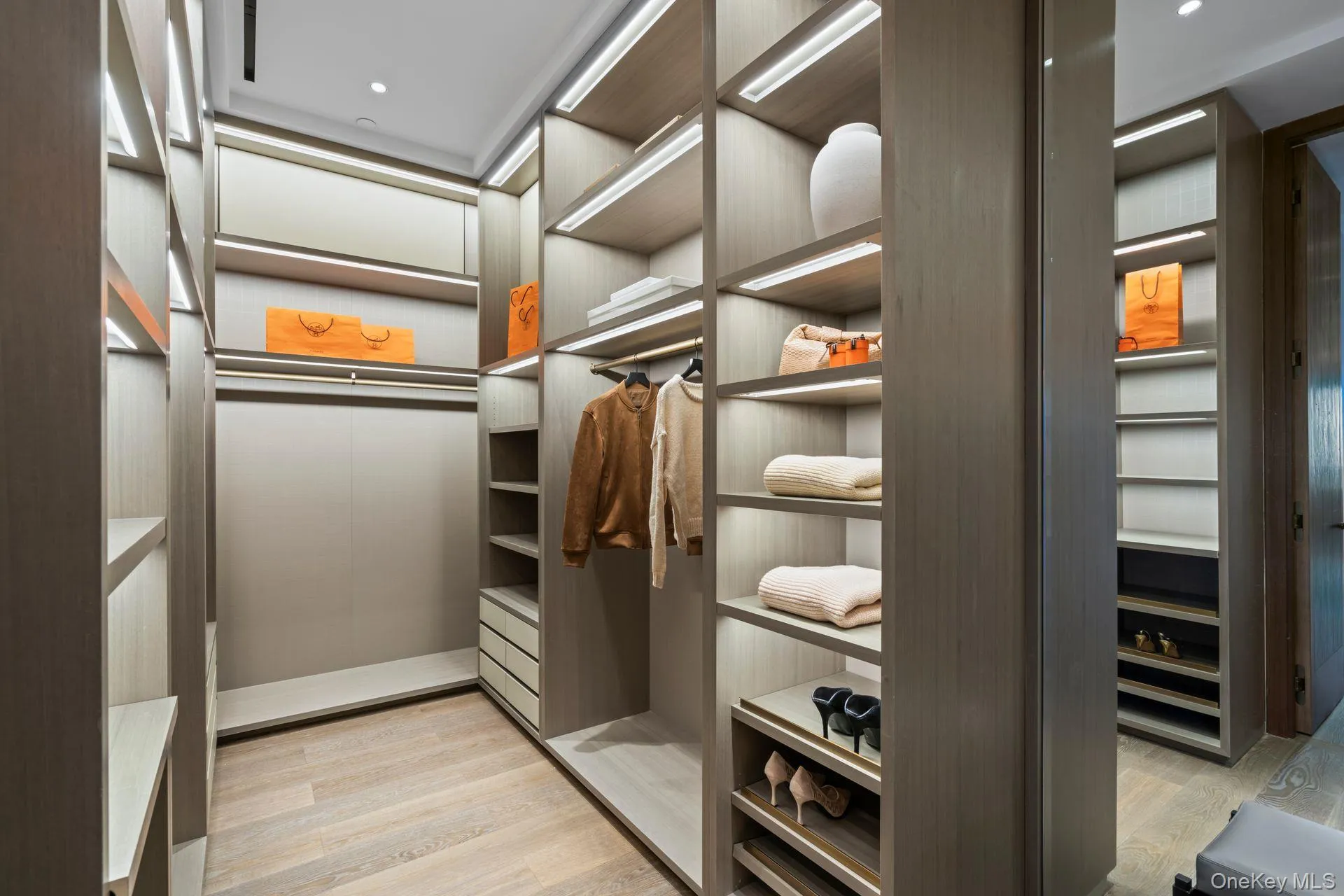Spacious closet featuring light wood-style flooring Spacious closet featuring light wood-style flooring