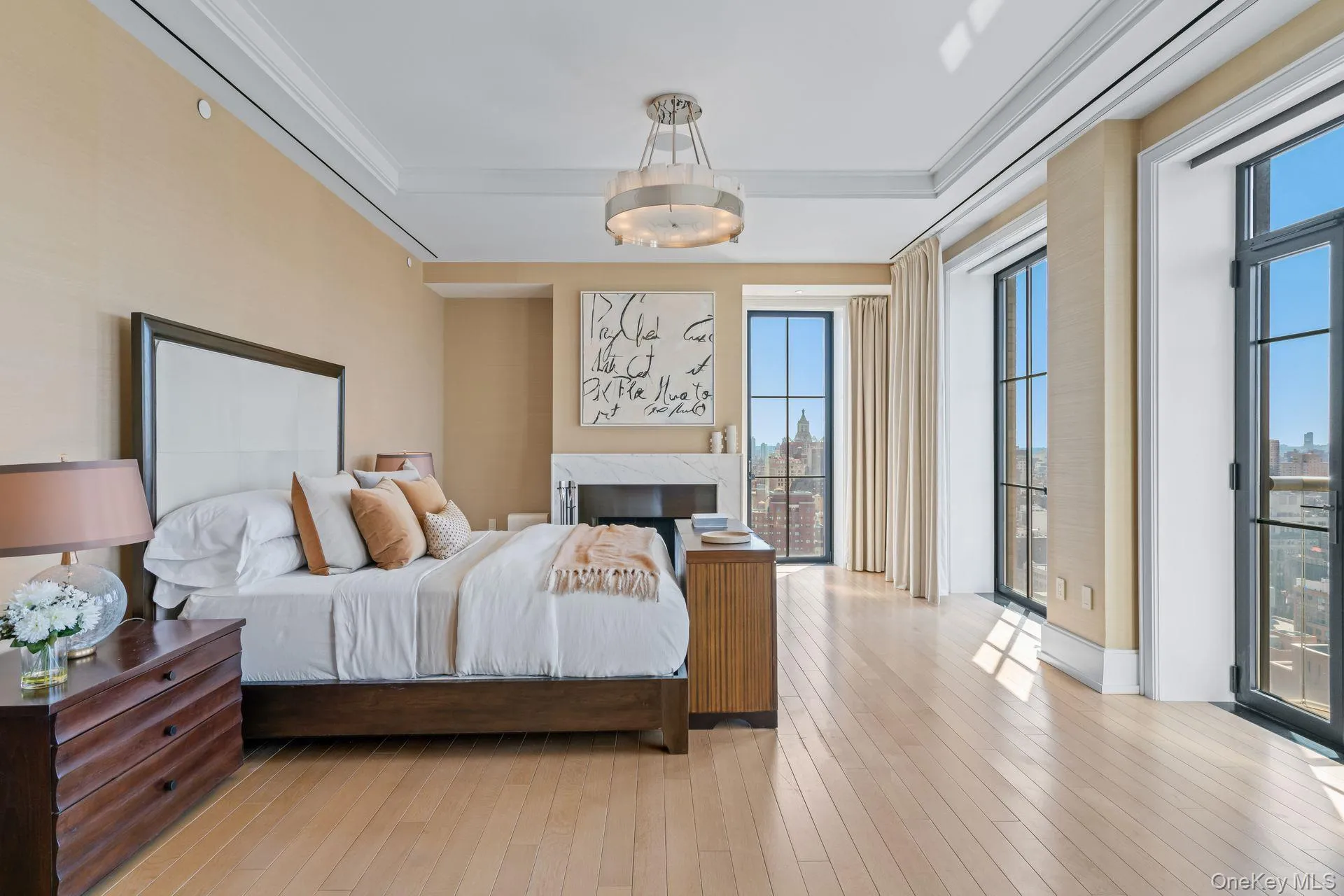 Bedroom with access to exterior, a premium fireplace, light wood-style floors, and crown molding Bedroom with access to exterior, a premium fireplace, light wood-style floors, and crown molding