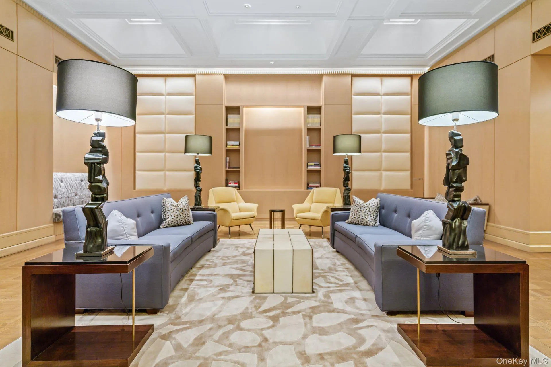 Living room with built in features, a decorative wall, baseboards, and coffered ceiling Living room with built in features, a decorative wall, baseboards, and coffered ceiling