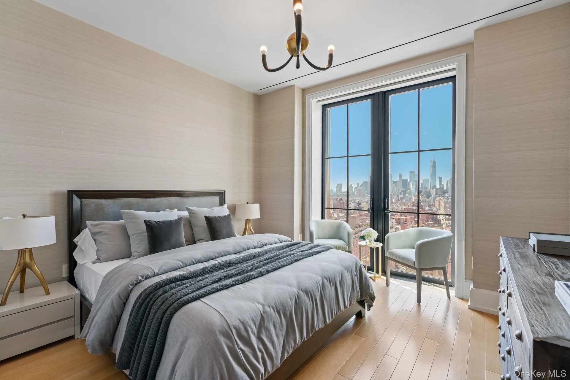 Bedroom with an inviting chandelier, light wood-style floors, and a city view Bedroom with an inviting chandelier, light wood-style floors, and a city view