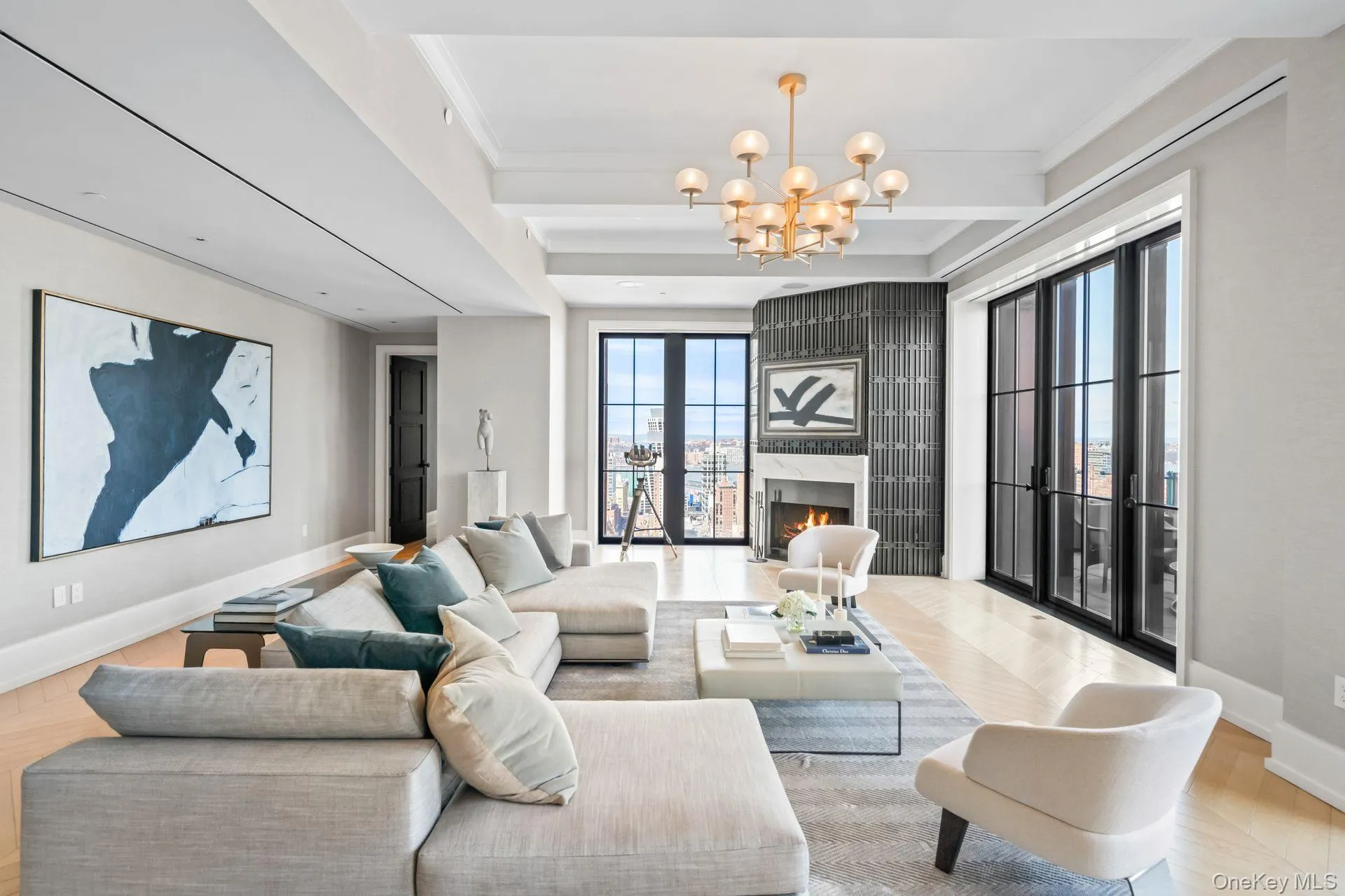 Living area with a high end fireplace, beamed ceiling, baseboards, wood finished floors, and an inviting chandelier Living area with a high end fireplace, beamed ceiling, baseboards, wood finished floors, and an inviting chandelier
