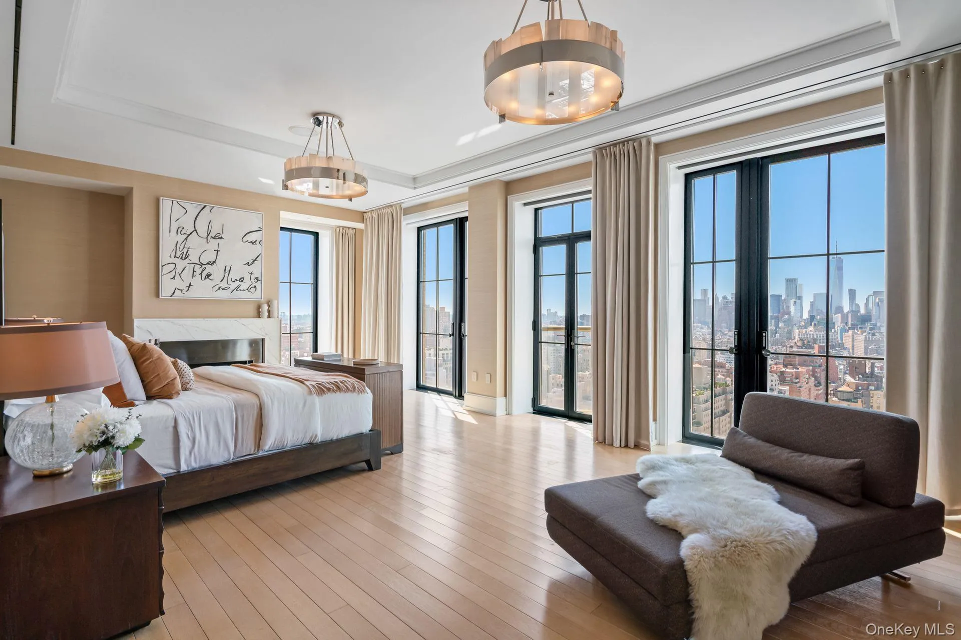 Bedroom with a tray ceiling, access to exterior, light wood-style flooring, and a city view Bedroom with a tray ceiling, access to exterior, light wood-style flooring, and a city view