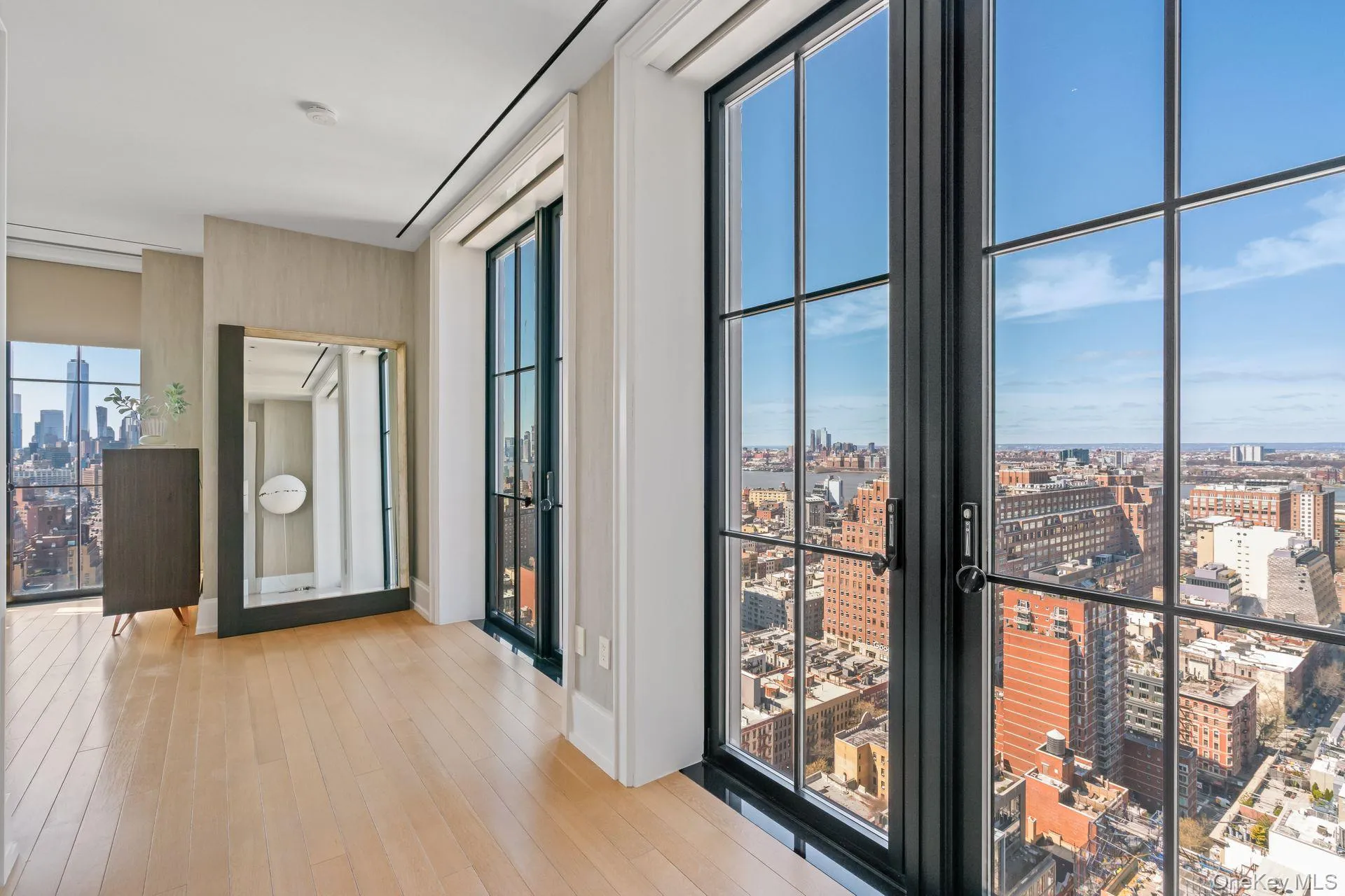 Hallway with french doors, a wall of windows, a city view, and light wood finished floors Hallway with french doors, a wall of windows, a city view, and light wood finished floors