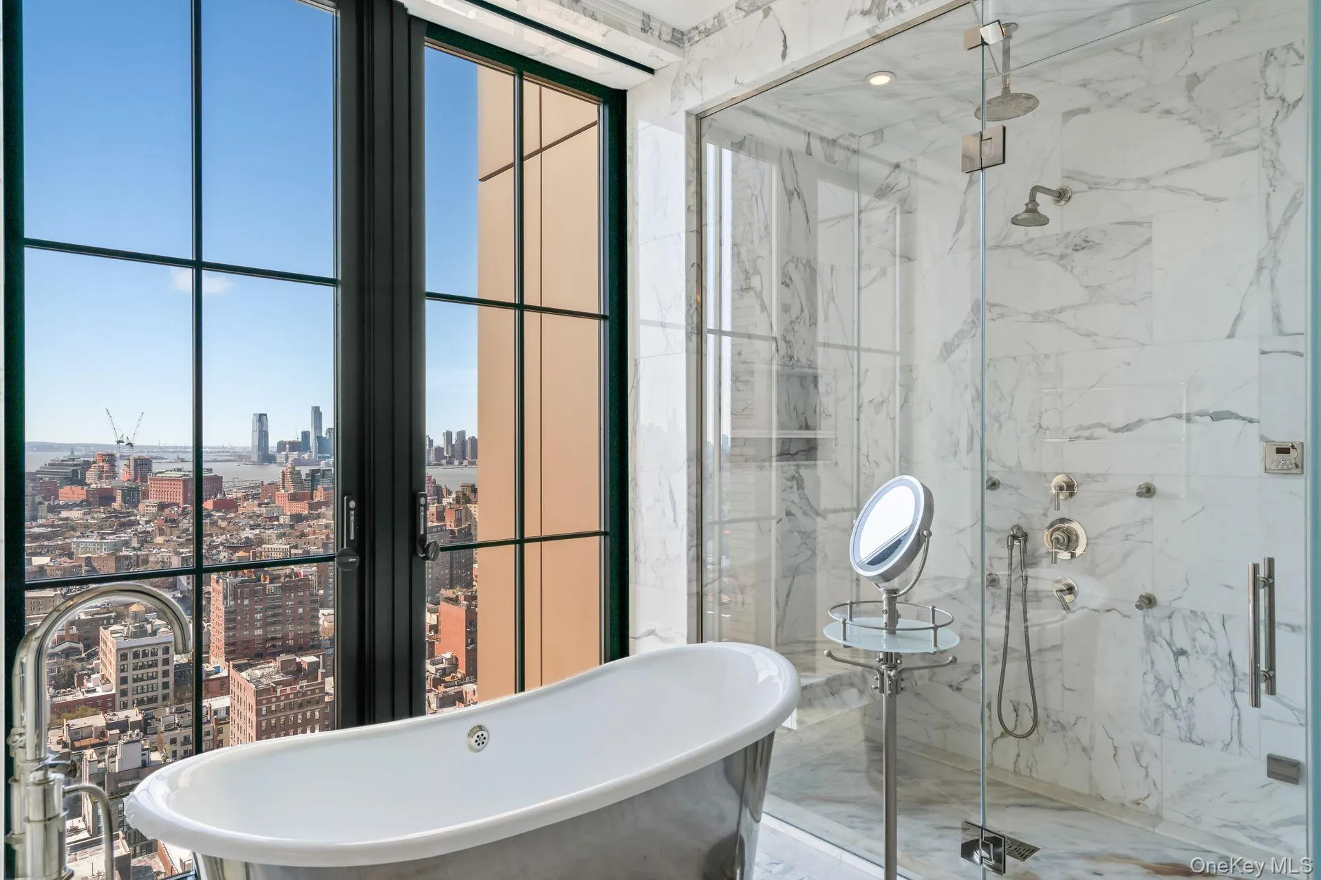 Full bath with a view of city, a marble finish shower, a freestanding tub, and marble finish floor Full bath with a view of city, a marble finish shower, a freestanding tub, and marble finish floor
