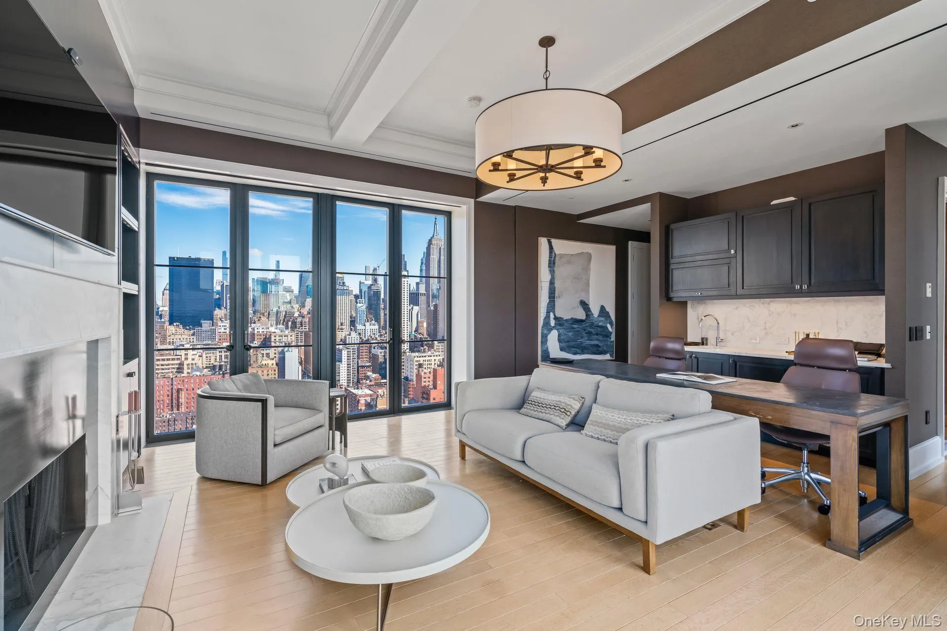 Living area with light wood-type flooring, ornamental molding, beamed ceiling, and a city view Living area with light wood-type flooring, ornamental molding, beamed ceiling, and a city view