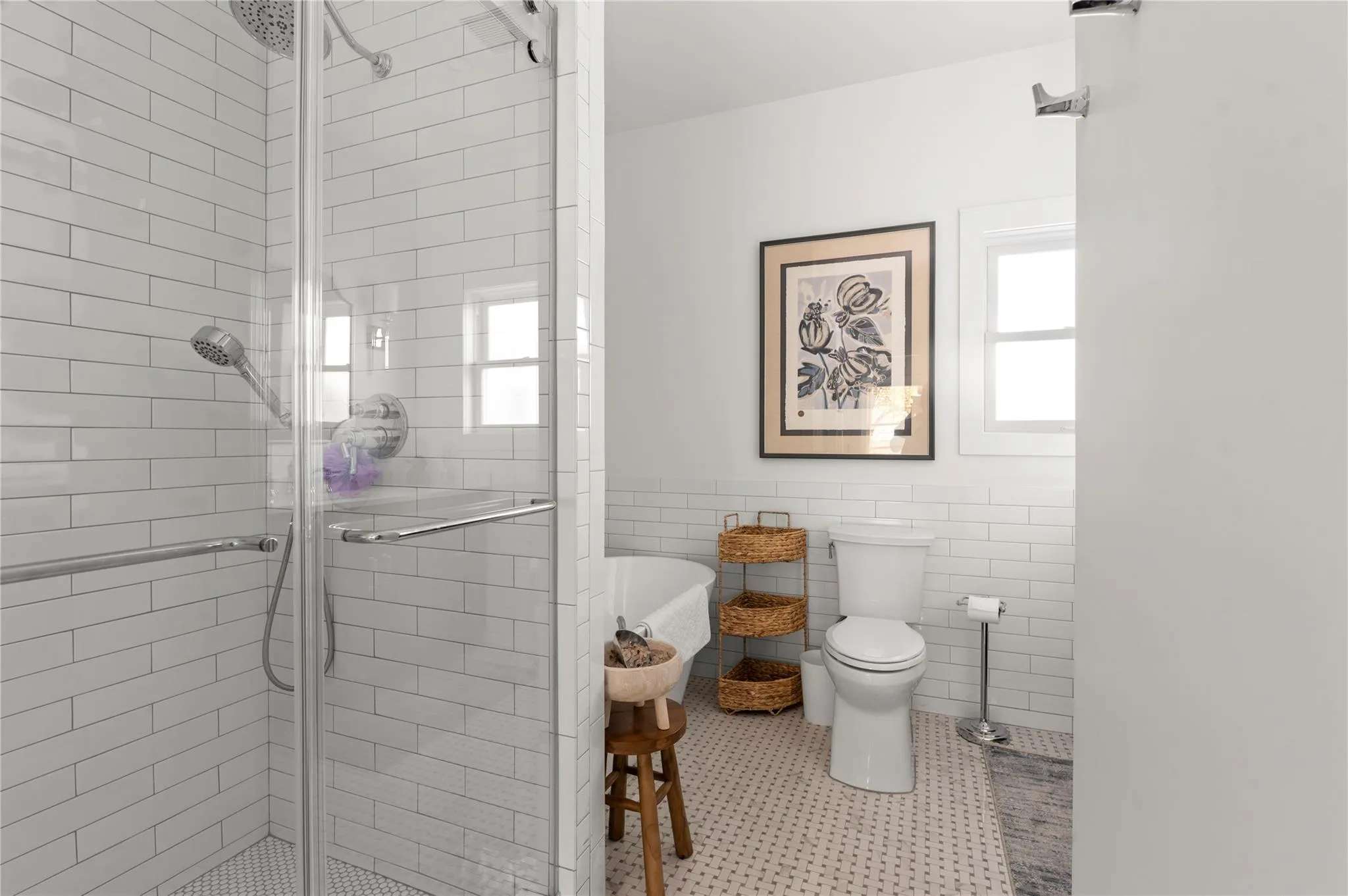 Full bathroom featuring healthy amount of natural light, a stall shower, toilet, a wainscoted wall, and tile walls Full bathroom featuring healthy amount of natural light, a stall shower, toilet, a wainscoted wall, and tile walls