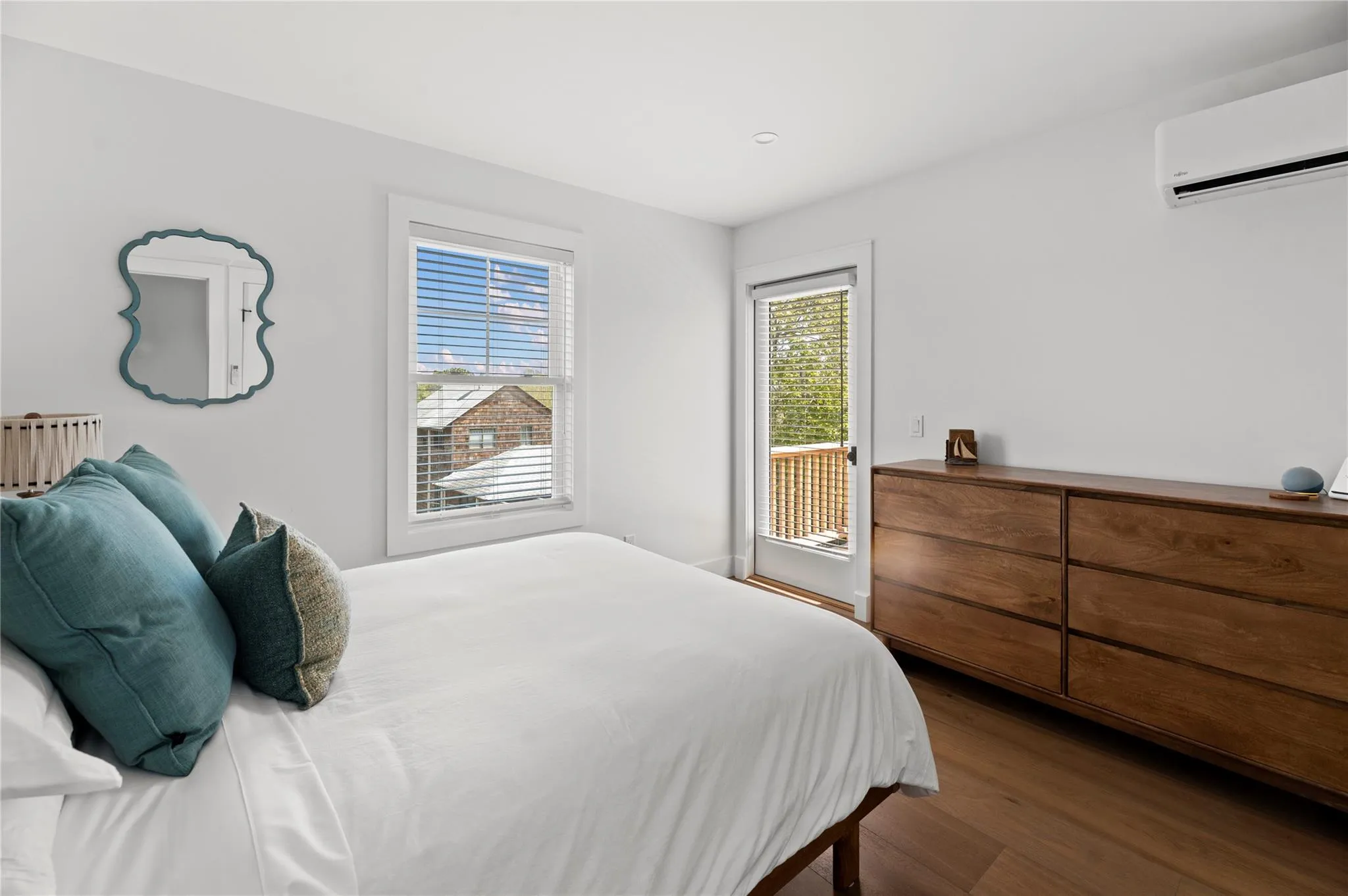 Bedroom with an AC wall unit and wood finished floors Bedroom with an AC wall unit and wood finished floors