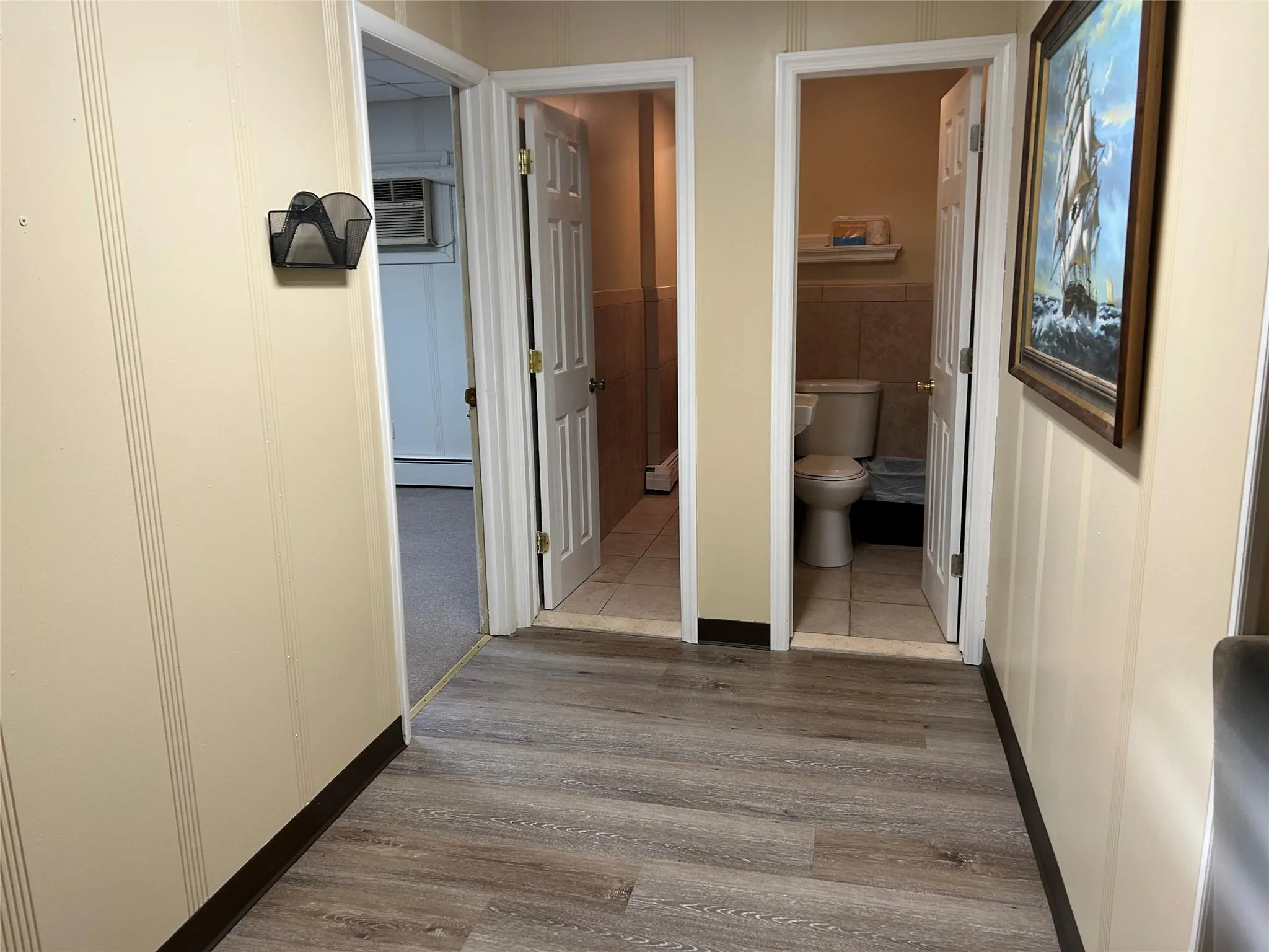 Corridor featuring a wall unit AC and a baseboard heating unit Corridor featuring a wall unit AC and a baseboard heating unit