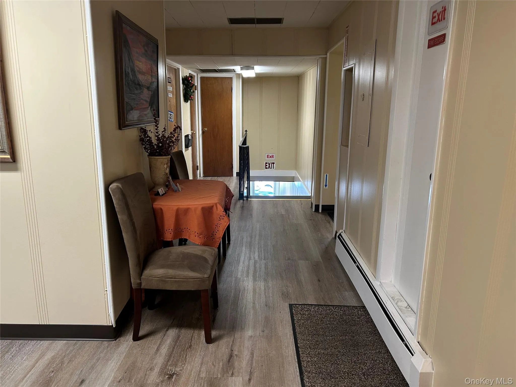 Hall featuring baseboard heating and light hardwood / wood-style floors Hall featuring baseboard heating and light hardwood / wood-style floors