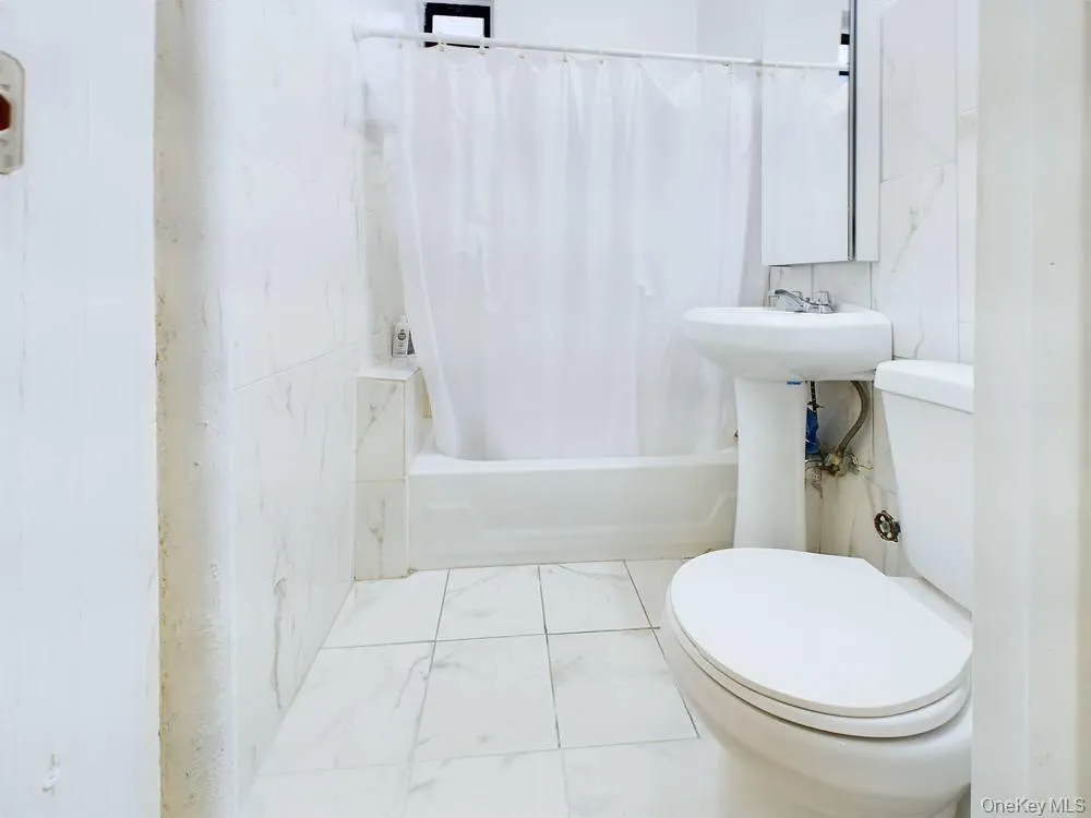 Bathroom with shower / bath combo with shower curtain and toilet Bathroom with shower / bath combo with shower curtain and toilet