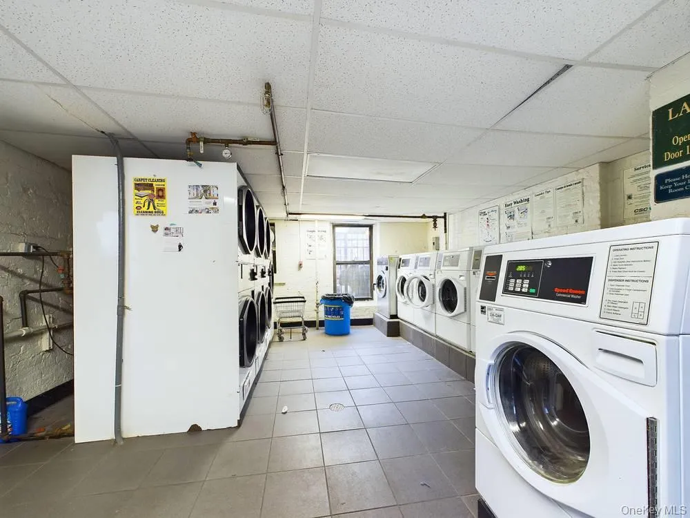 Laundry area with washer and dryer, tile patterned floors, and stacked washer / drying machine Laundry area with washer and dryer, tile patterned floors, and stacked washer / drying machine