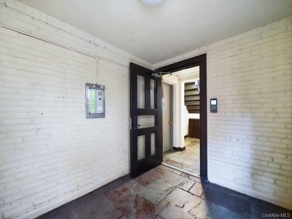 Foyer featuring brick wall Foyer featuring brick wall