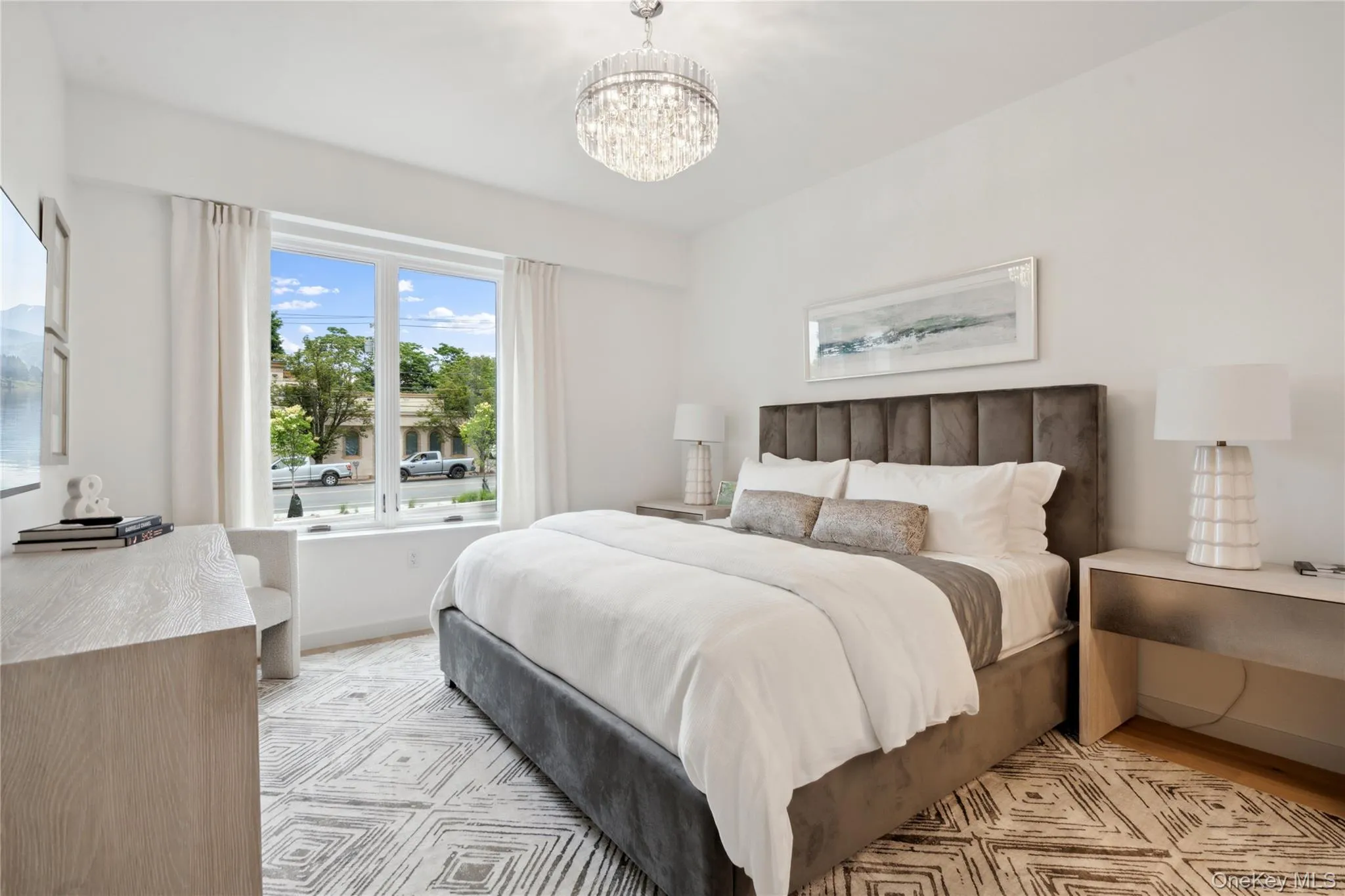 Bedroom featuring light wood-type flooring and an inviting chandelier Bedroom featuring light wood-type flooring and an inviting chandelier