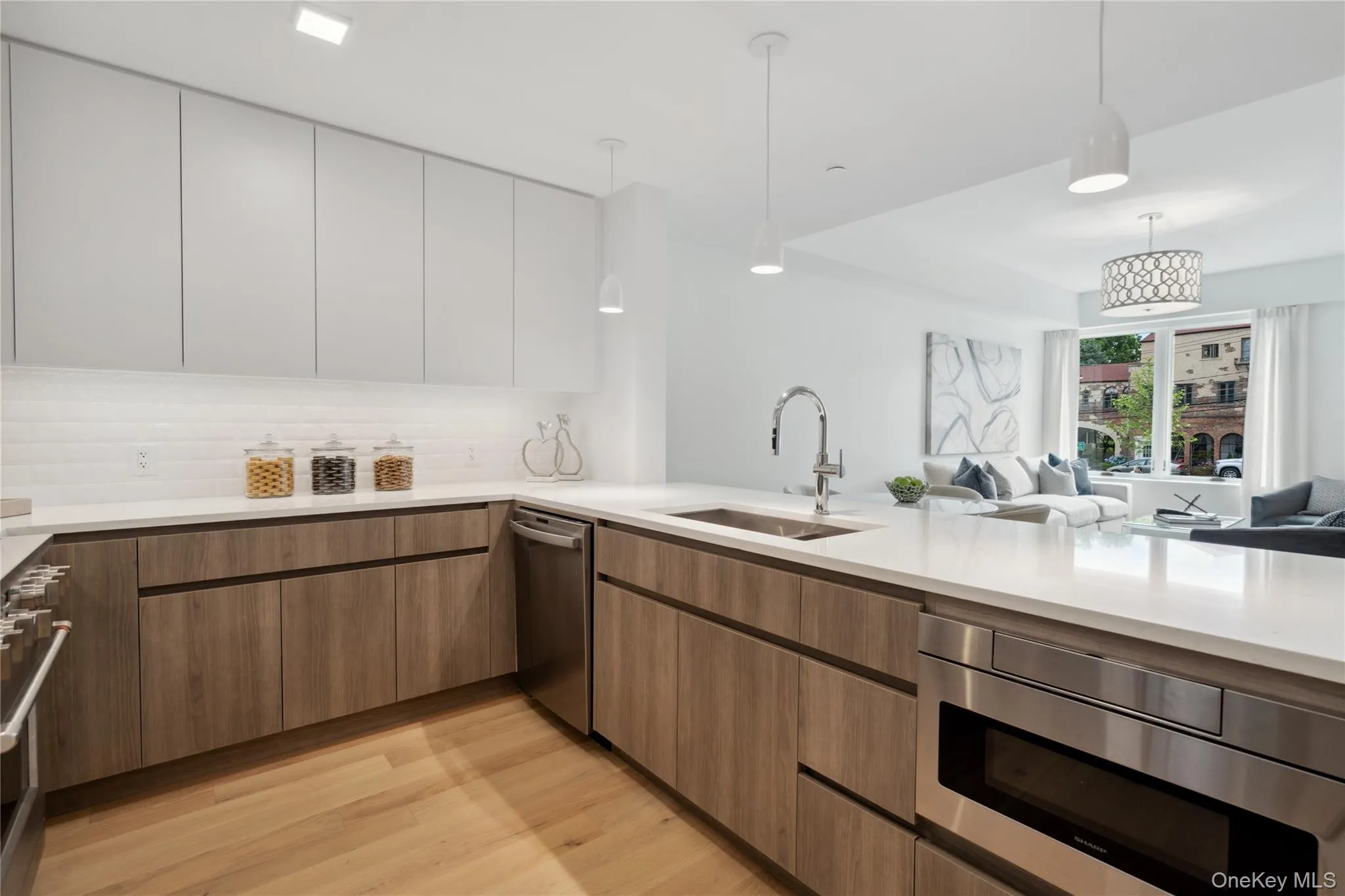 Kitchen with white cabinetry, sink, dishwasher, pendant lighting, and light wood-type flooring Kitchen with white cabinetry, sink, dishwasher, pendant lighting, and light wood-type flooring