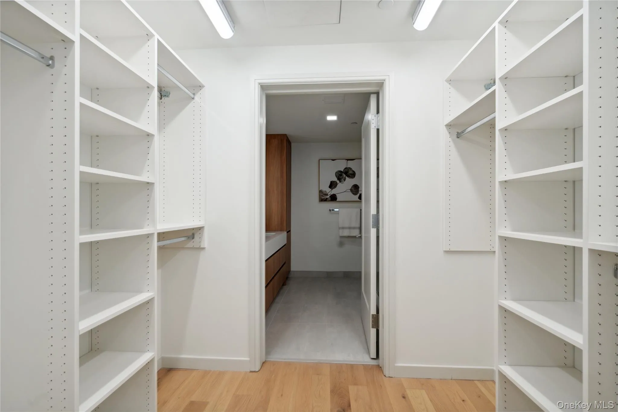 Spacious closet with light hardwood / wood-style flooring Spacious closet with light hardwood / wood-style flooring
