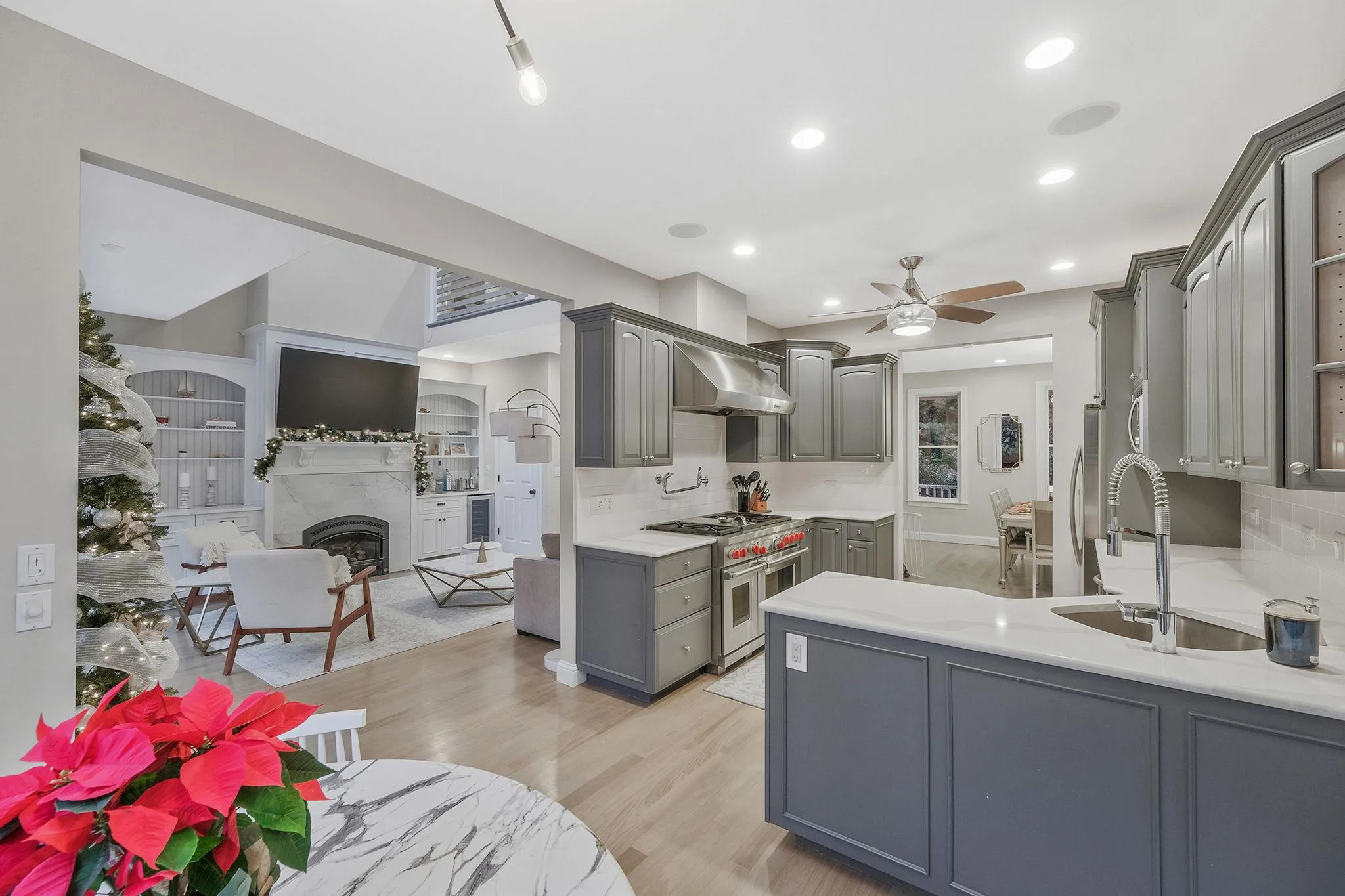 Kitchen featuring ceiling fan, sink, stainless steel appliances, gray cabinets, and light wood-type flooring Kitchen featuring ceiling fan, sink, stainless steel appliances, gray cabinets, and light wood-type flooring