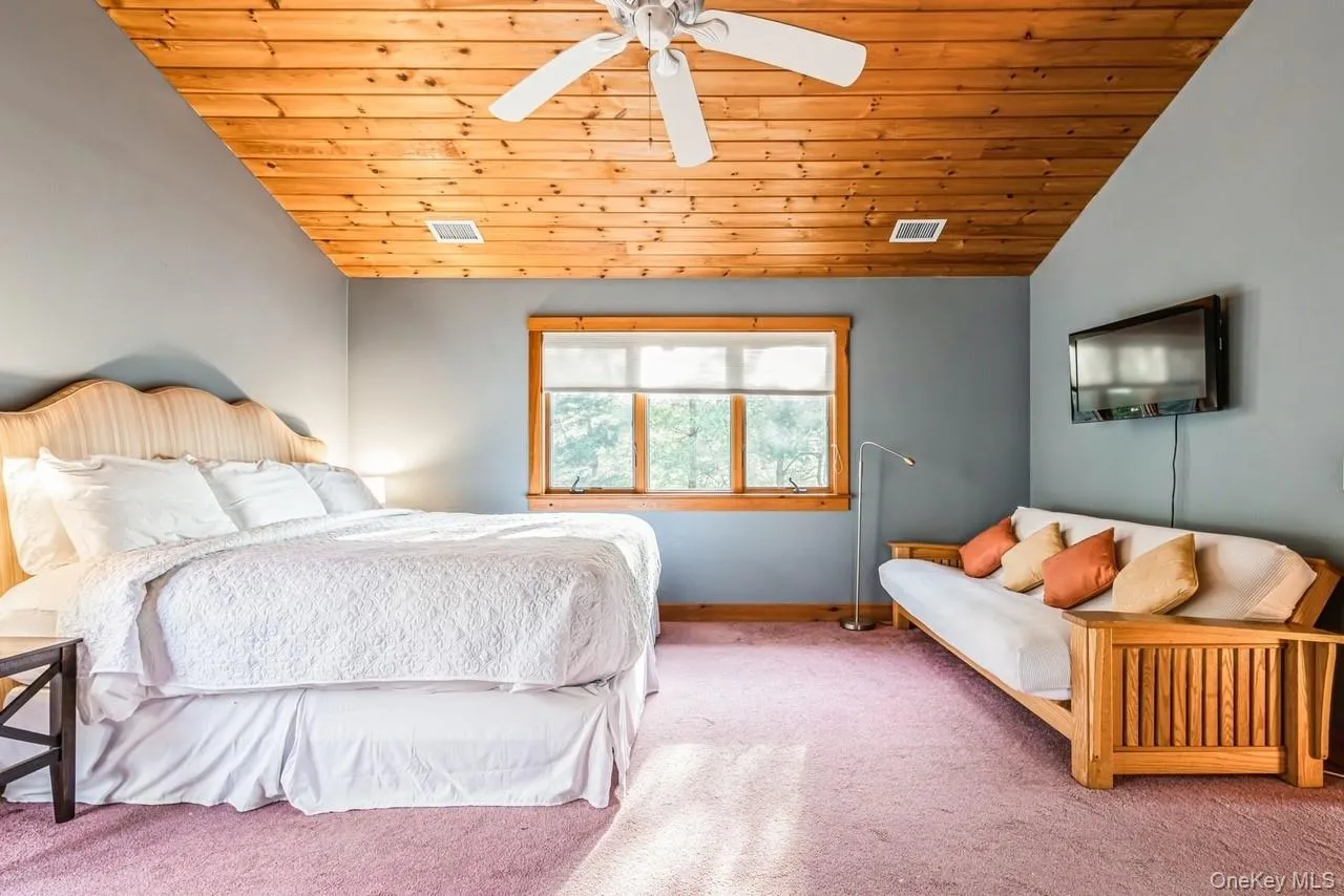 Primary Bedroom with high  ceiling, ceiling fan, and wooden ceiling