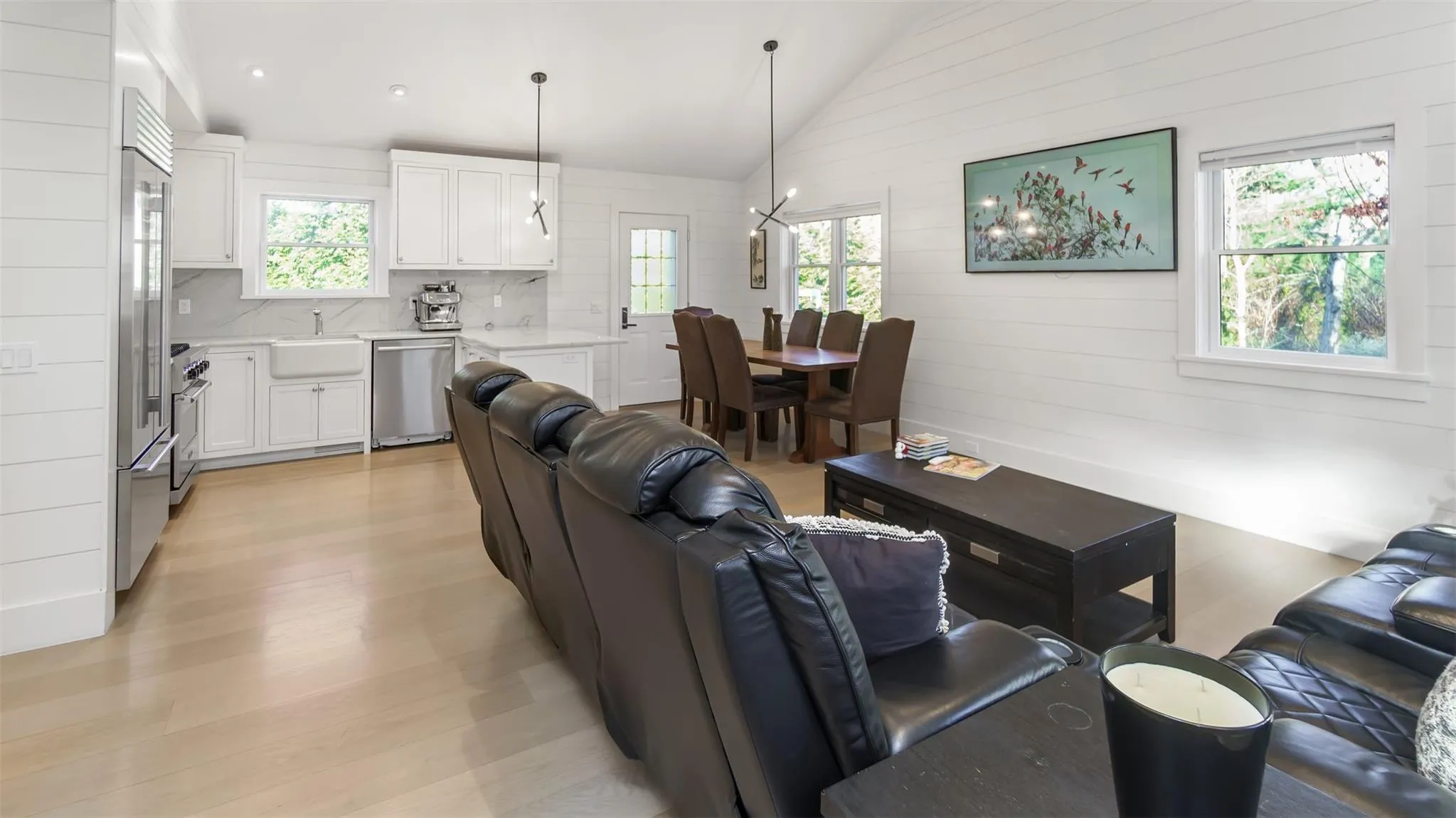 Living room with sink, a healthy amount of sunlight, vaulted ceiling, and light wood-type flooring Living room with sink, a healthy amount of sunlight, vaulted ceiling, and light wood-type flooring