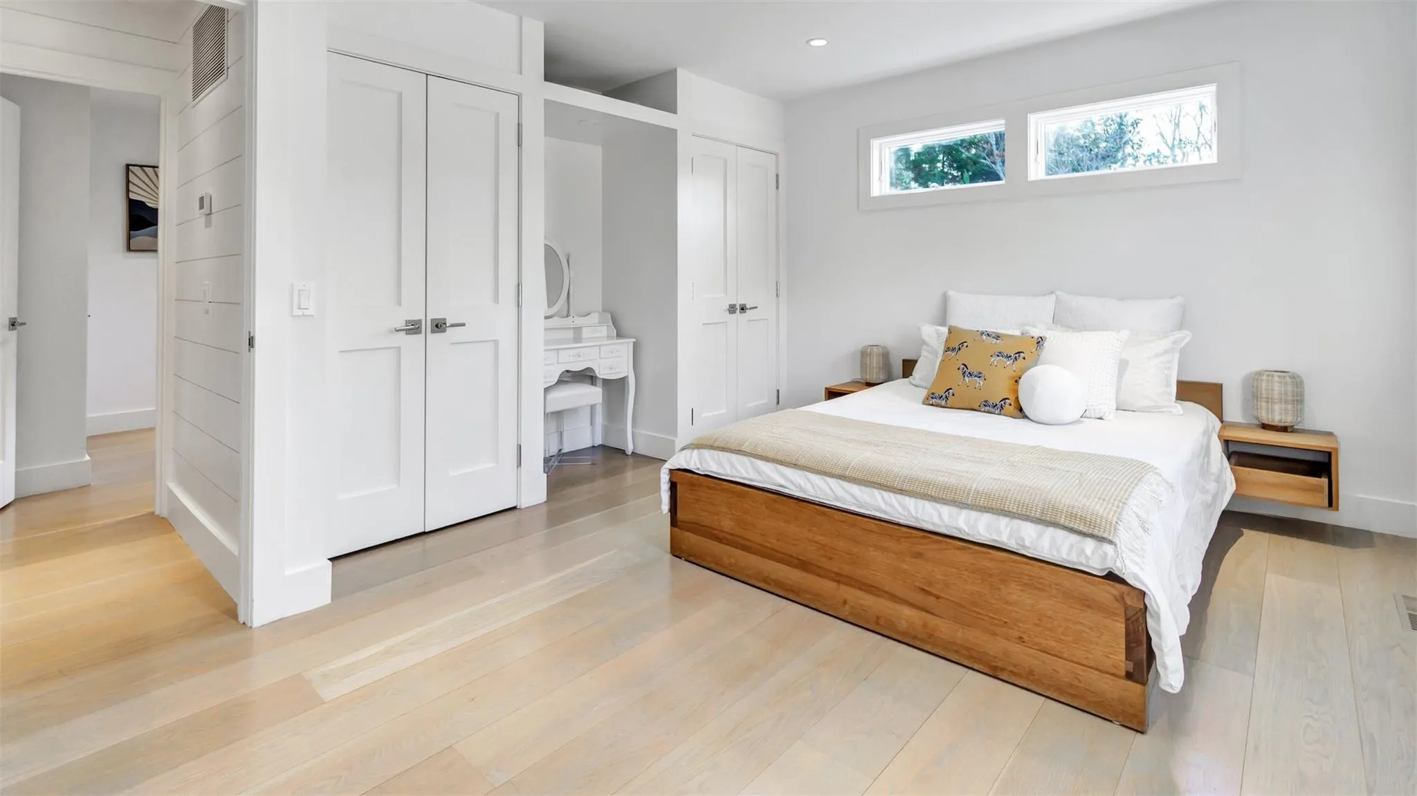 Bedroom featuring multiple closets and light hardwood / wood-style flooring Bedroom featuring multiple closets and light hardwood / wood-style flooring