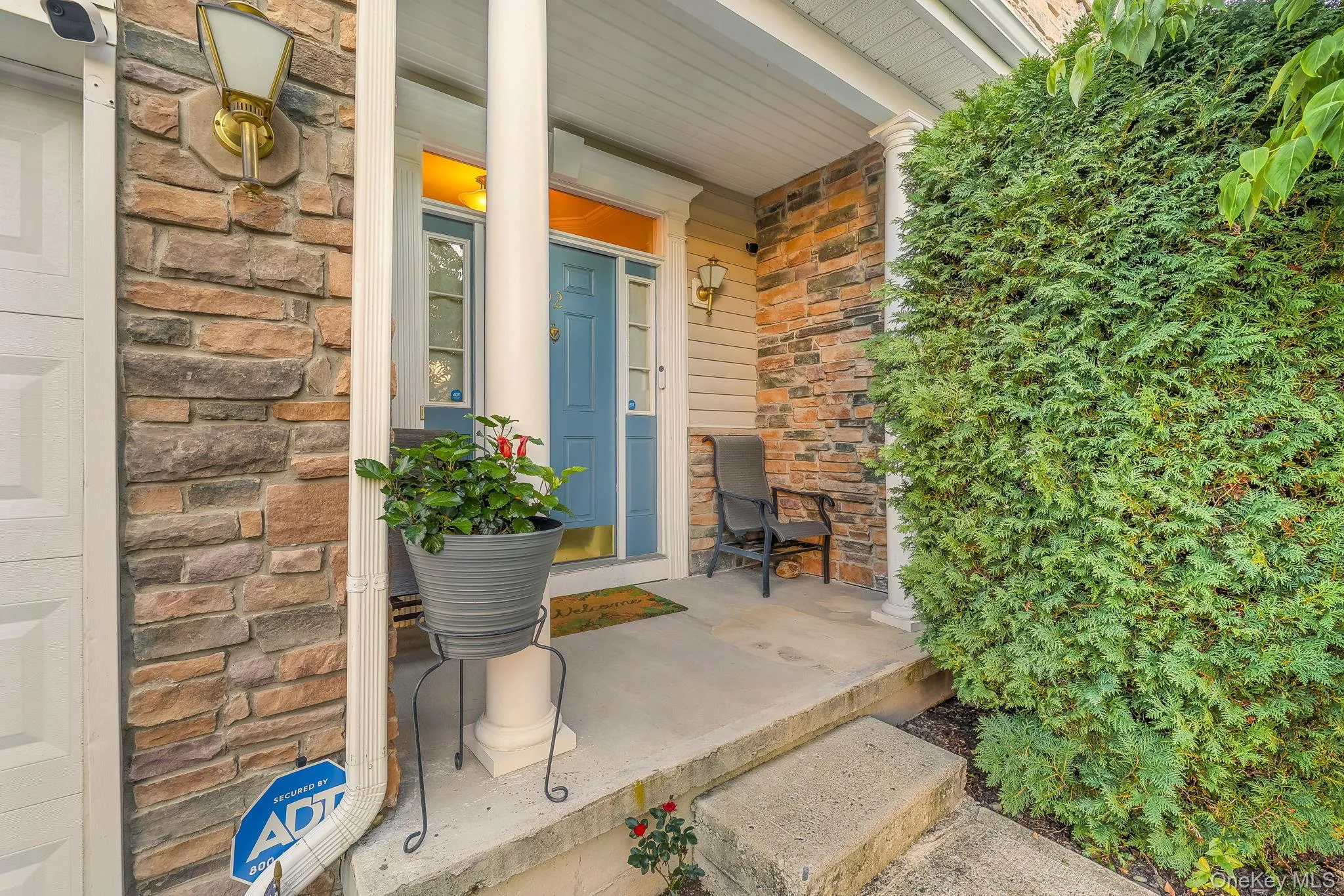 Stone veneer facade, covered front porch, concrete steps, columned entry, blue front door Stone veneer facade, covered front porch, concrete steps, columned entry, blue front door