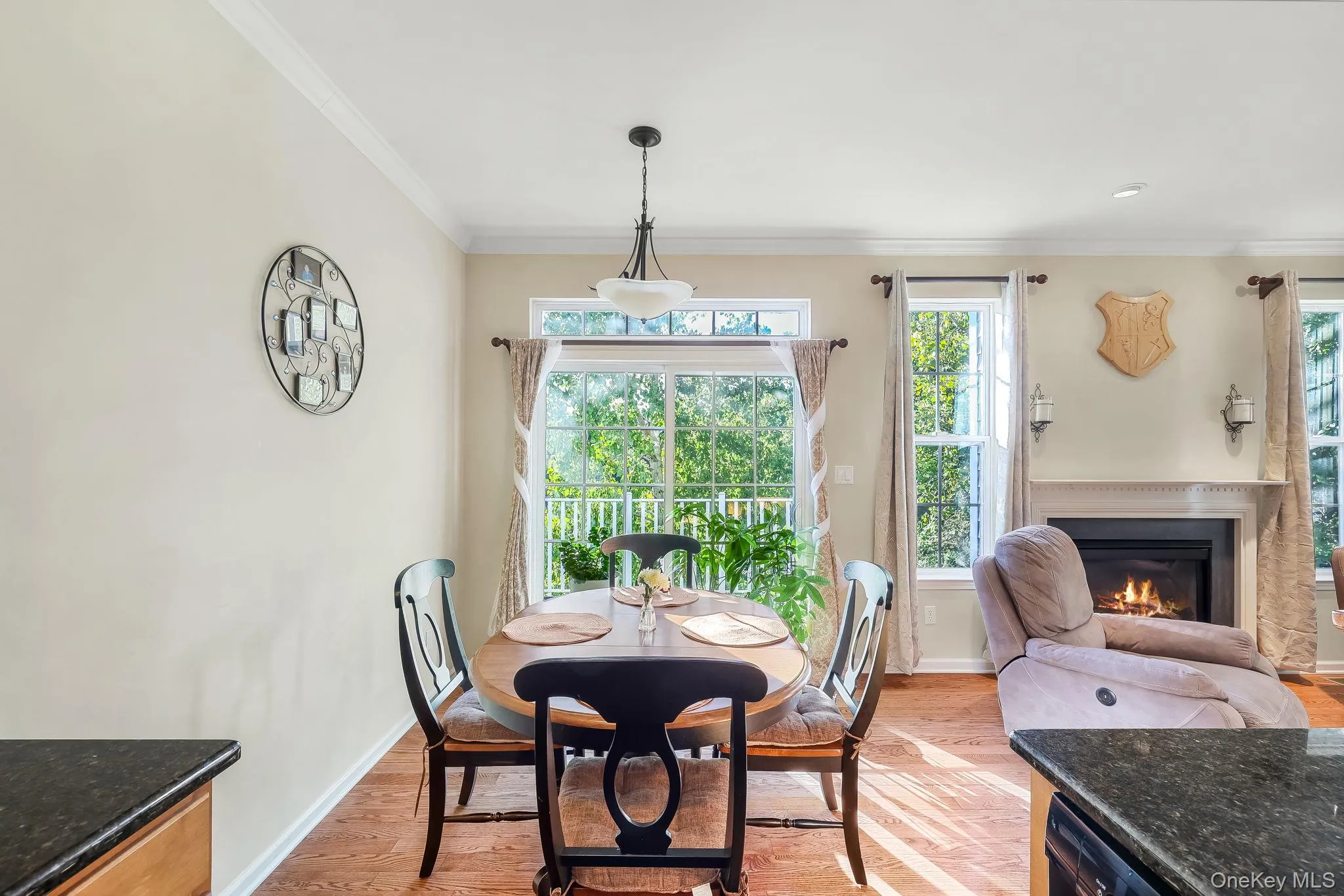 Hardwood flooring, crown molding, fireplace with mantel, recessed lighting, and a sliding glass door Hardwood flooring, crown molding, fireplace with mantel, recessed lighting, and a sliding glass door