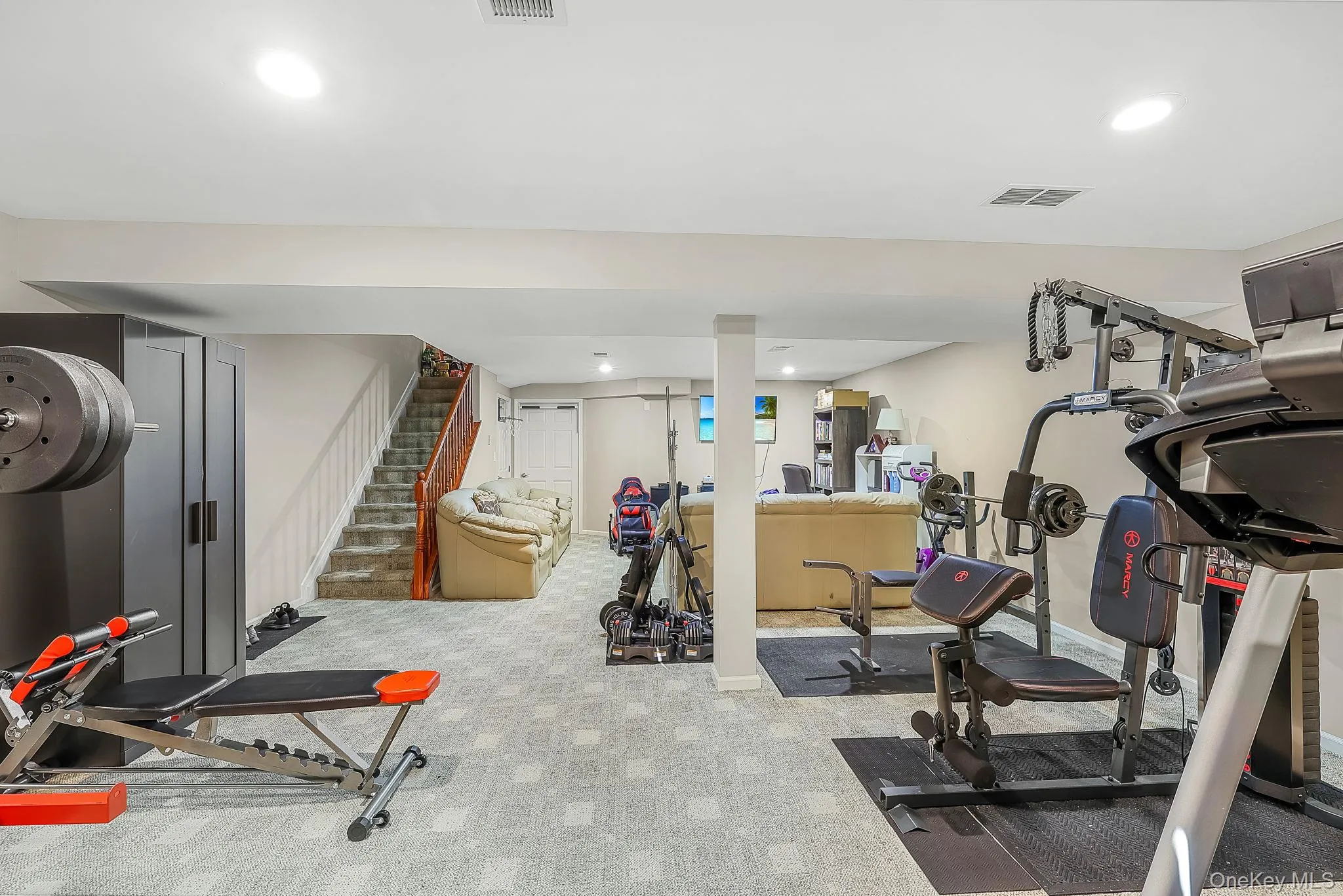 Finished basement space featuring recessed lighting, carpeted flooring, and a structural column Finished basement space featuring recessed lighting, carpeted flooring, and a structural column