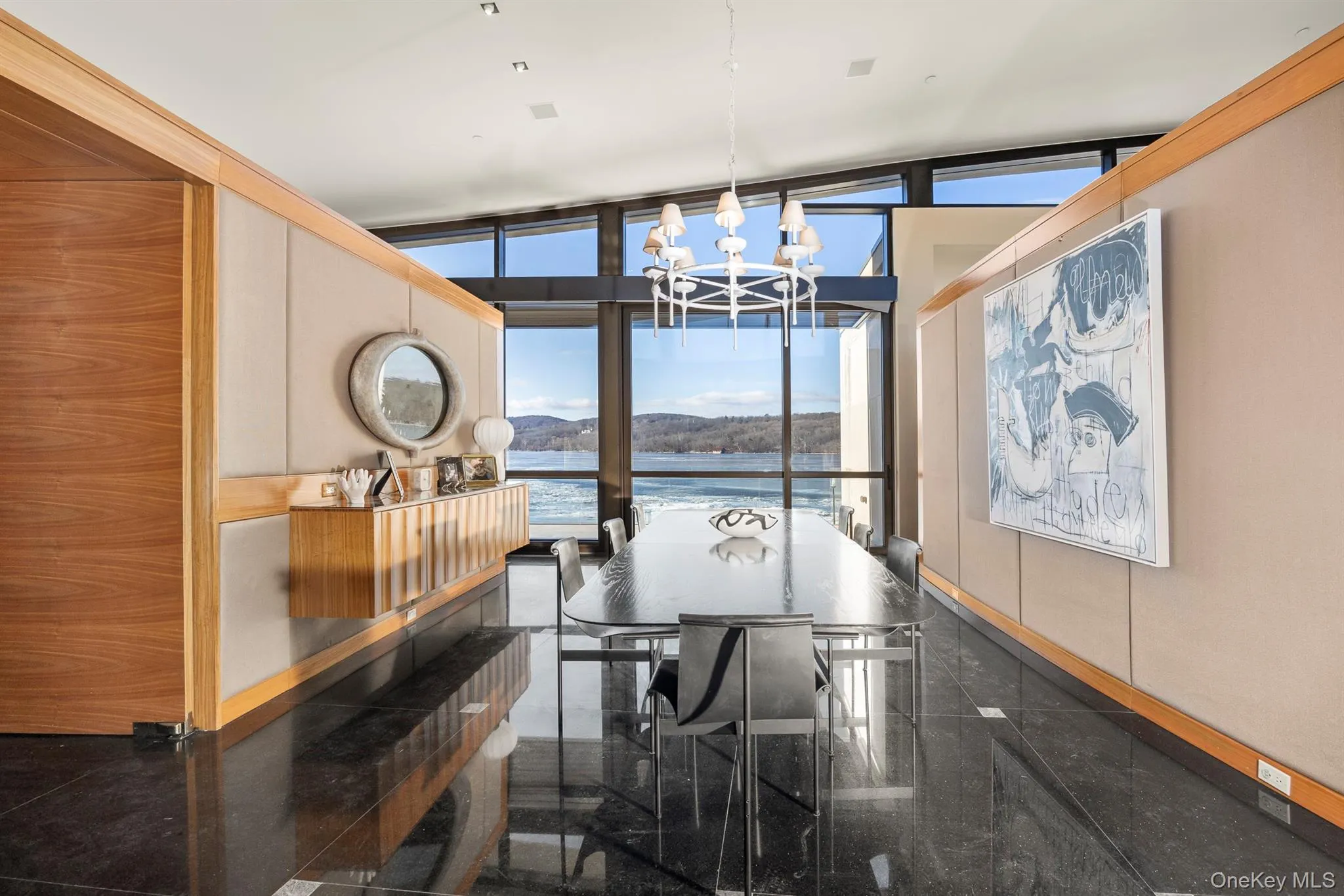 Dining area with expansive windows, plenty of natural light, and a water view Dining area with expansive windows, plenty of natural light, and a water view