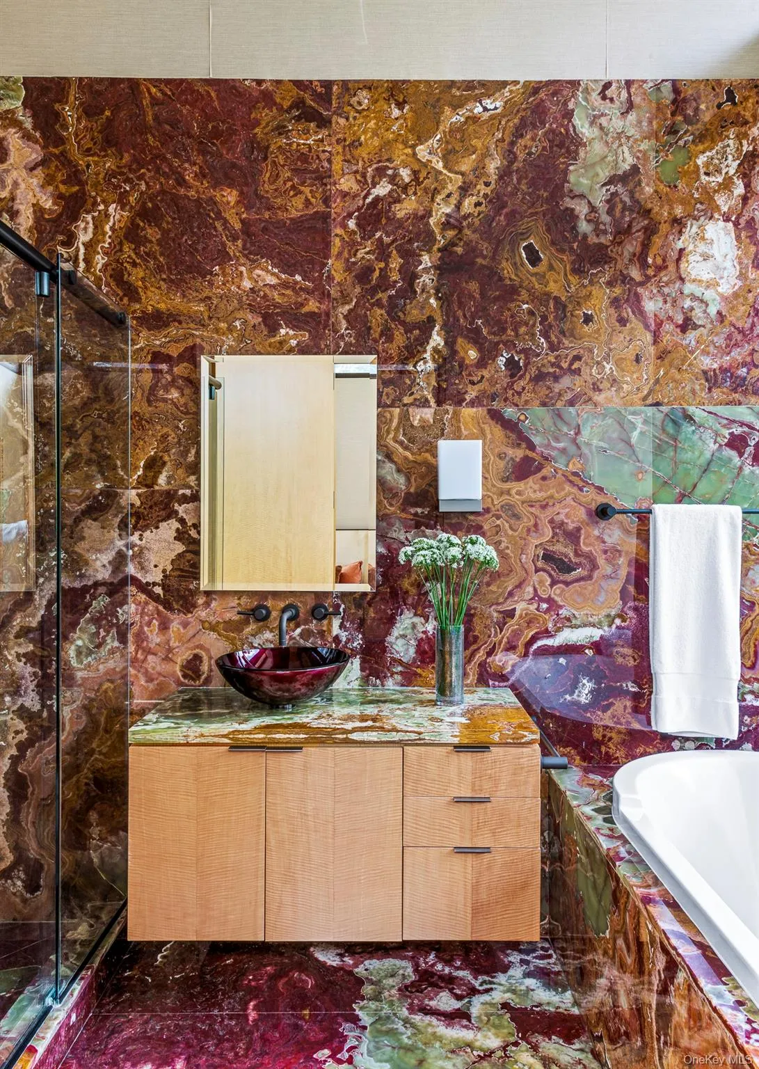 Bathroom featuring tiled tub and vanity Bathroom featuring tiled tub and vanity