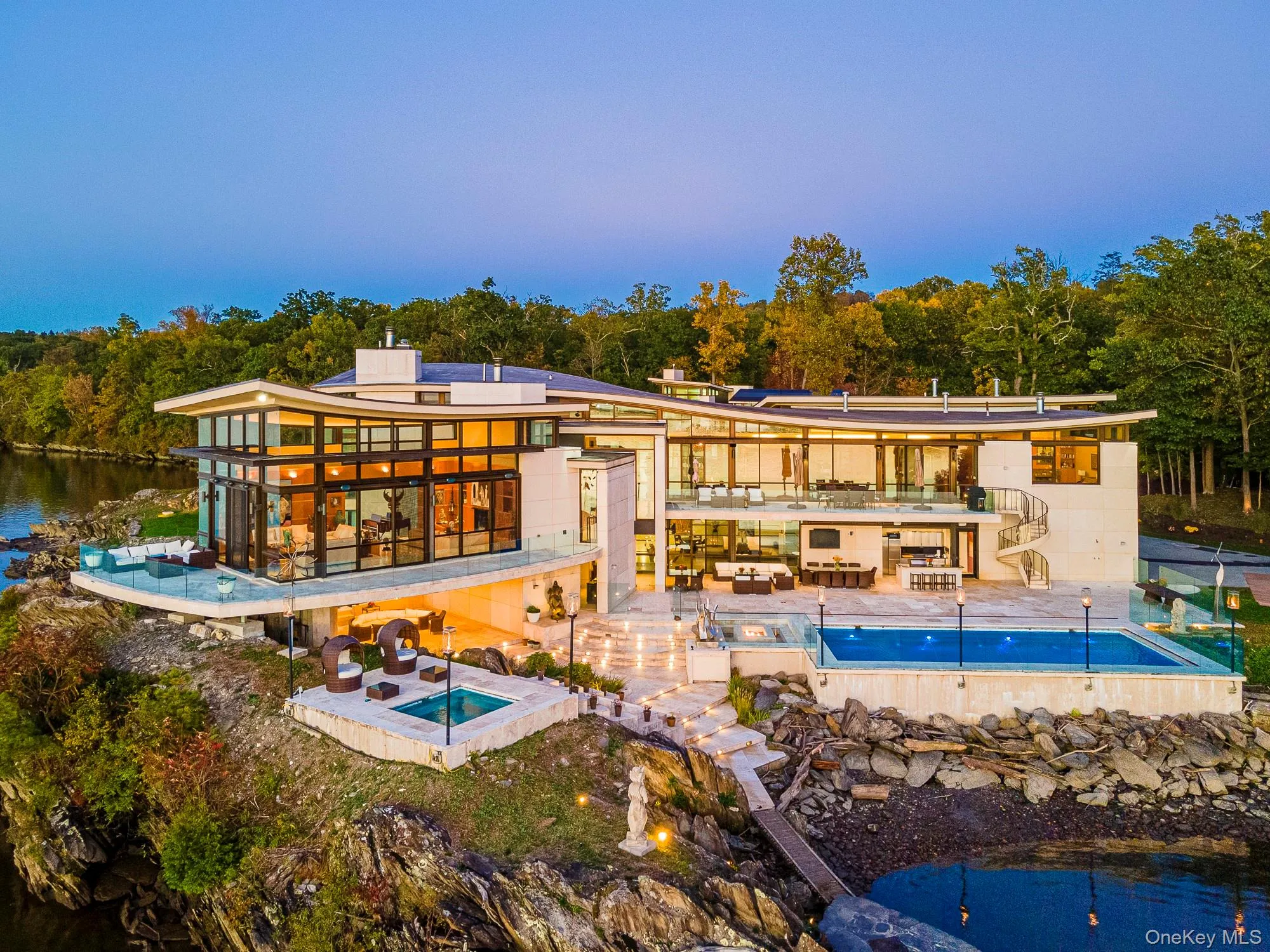 Back of property with a patio area, a swimming pool with hot tub, and a water view Back of property with a patio area, a swimming pool with hot tub, and a water view