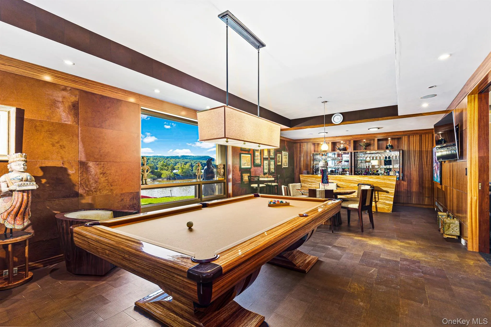 Game room featuring a raised ceiling, wooden walls, indoor bar, and pool table Game room featuring a raised ceiling, wooden walls, indoor bar, and pool table
