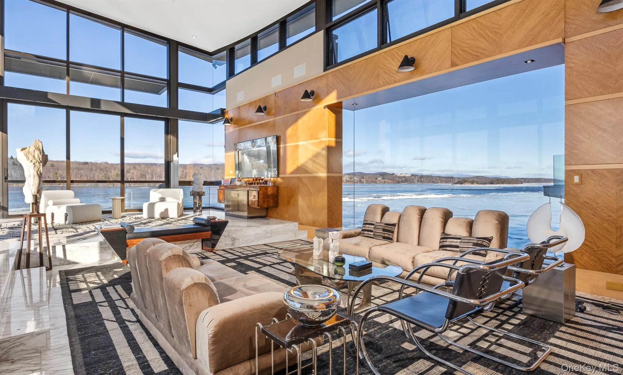 Living room featuring wood walls, a water view, and a high ceiling Living room featuring wood walls, a water view, and a high ceiling
