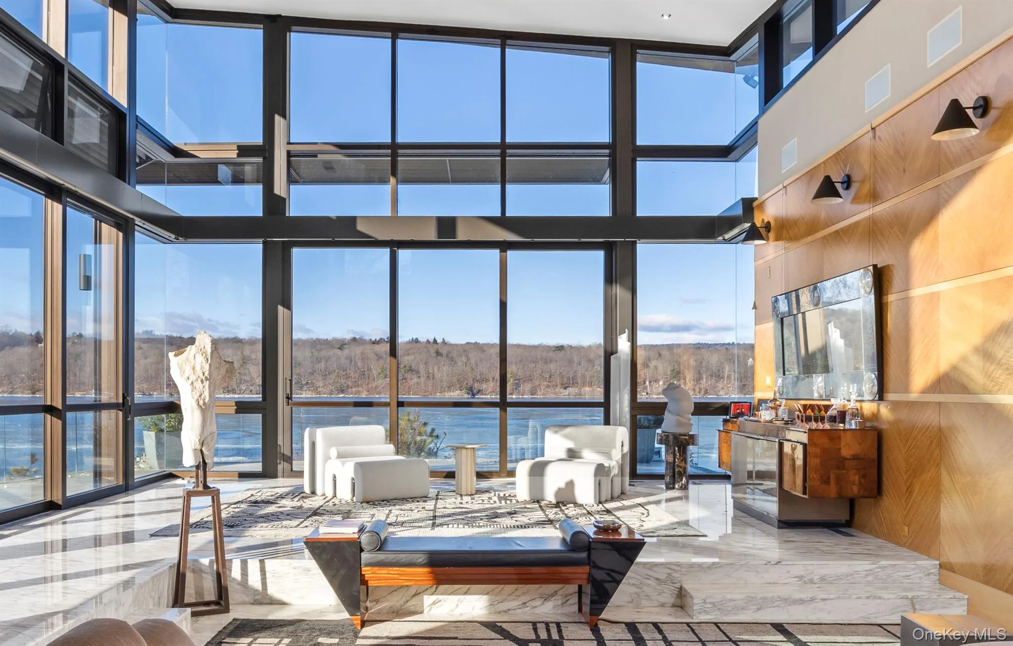 Living room with a fireplace, a towering ceiling, and a water view Living room with a fireplace, a towering ceiling, and a water view