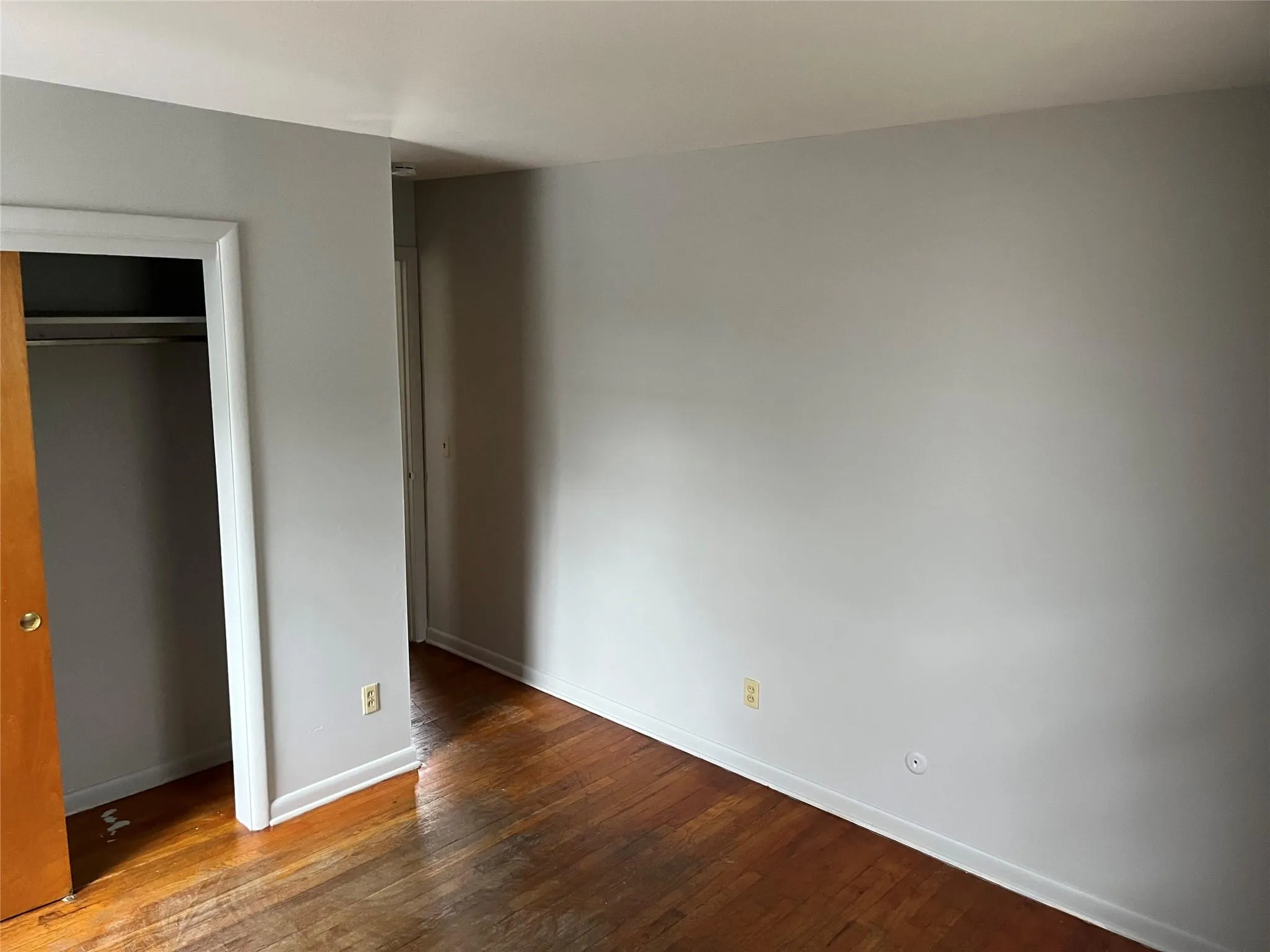 Unfurnished bedroom with hardwood / wood-style flooring and a closet Unfurnished bedroom with hardwood / wood-style flooring and a closet