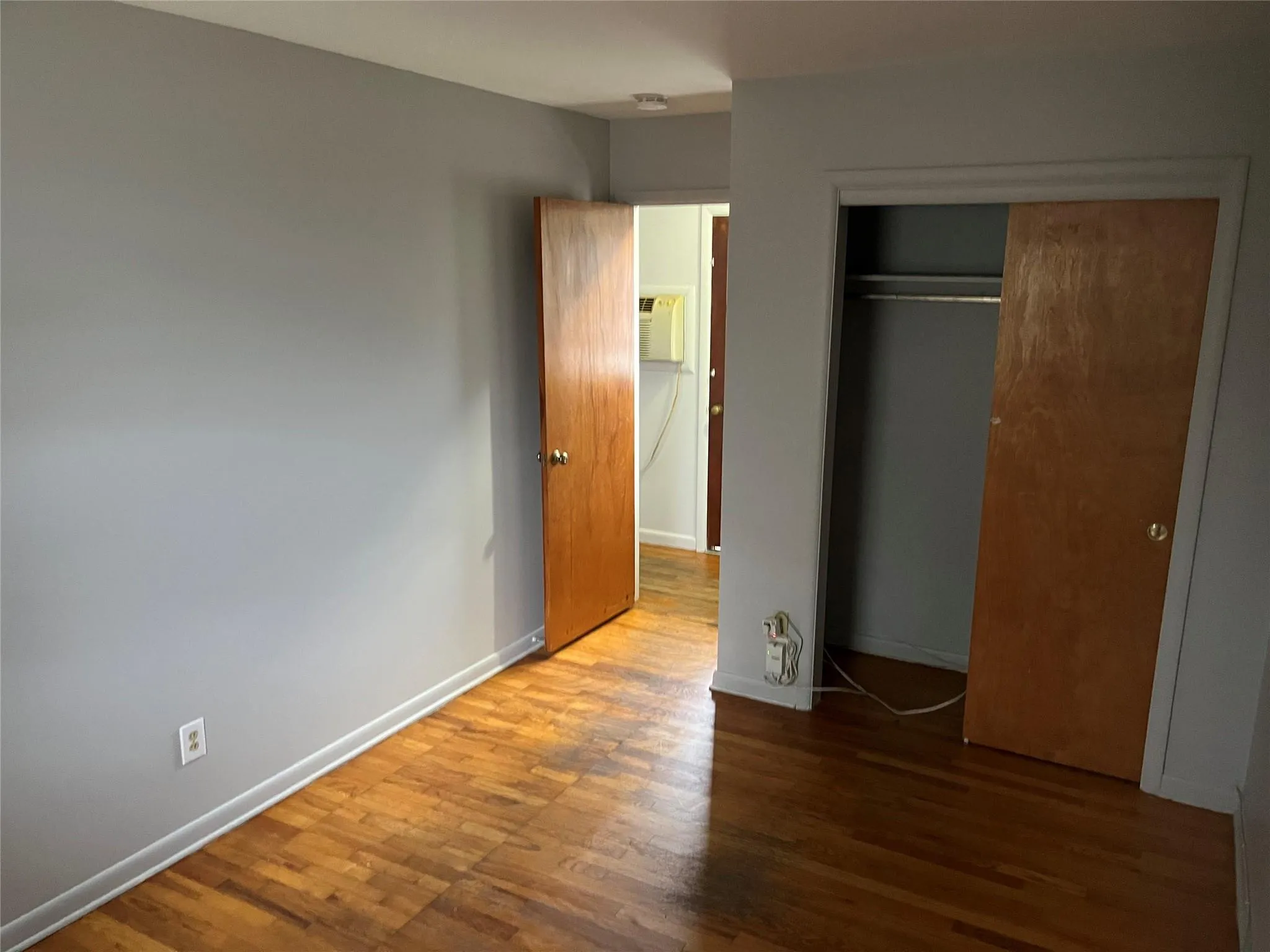 Unfurnished bedroom with hardwood / wood-style flooring and a closet Unfurnished bedroom with hardwood / wood-style flooring and a closet