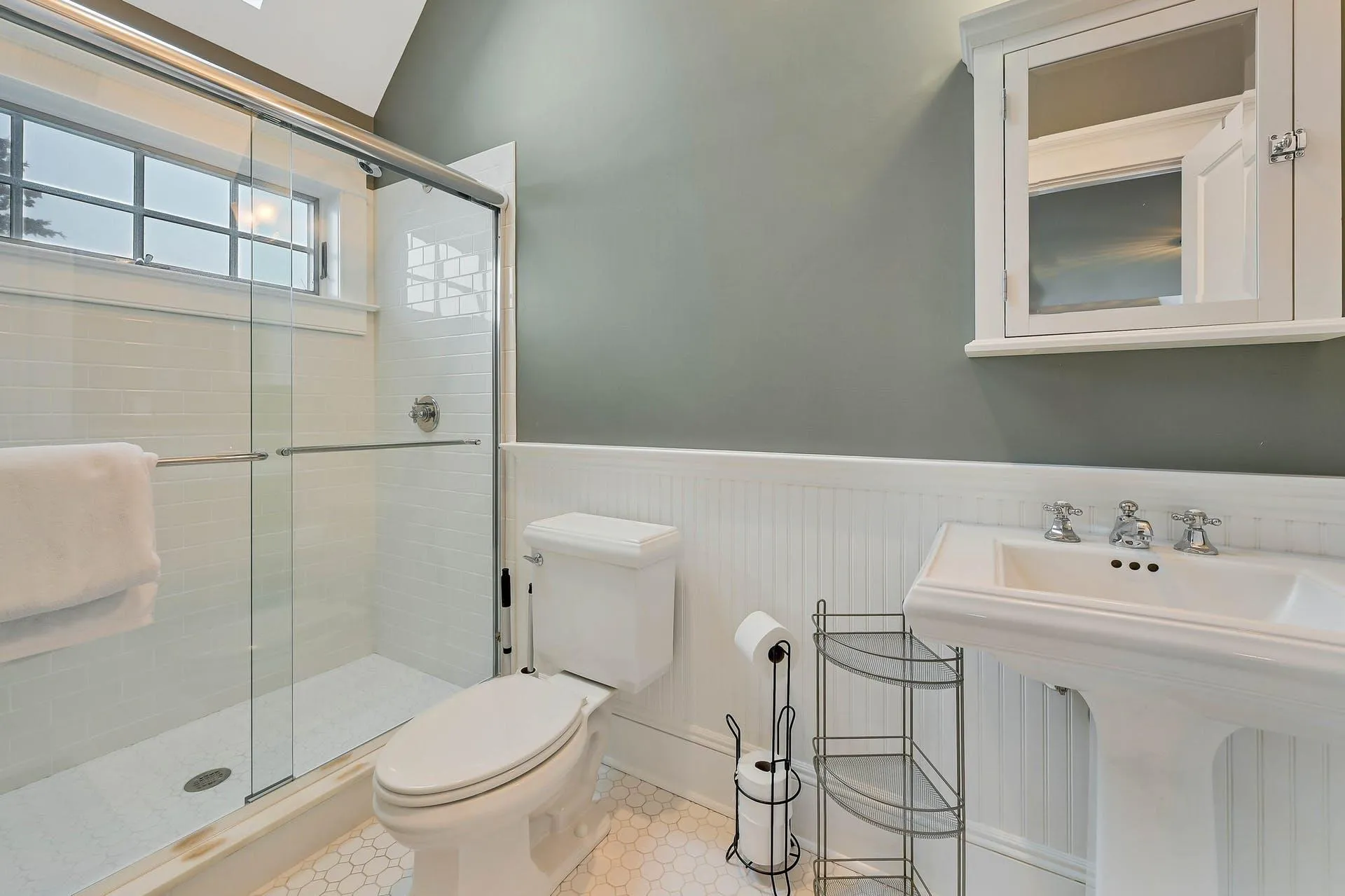 Bathroom featuring tile patterned floors, sink, a shower with door, and toilet Bathroom featuring tile patterned floors, sink, a shower with door, and toilet