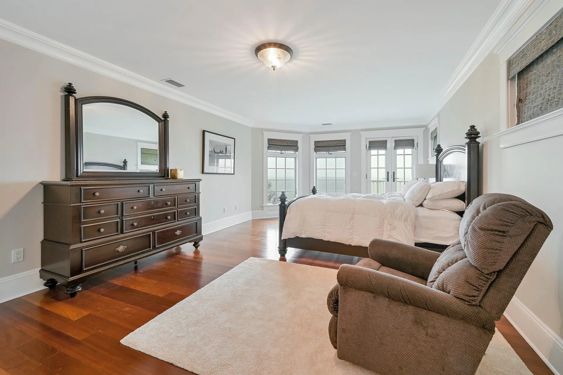 Bedroom with french doors, crown molding, and dark wood-type flooring Bedroom with french doors, crown molding, and dark wood-type flooring